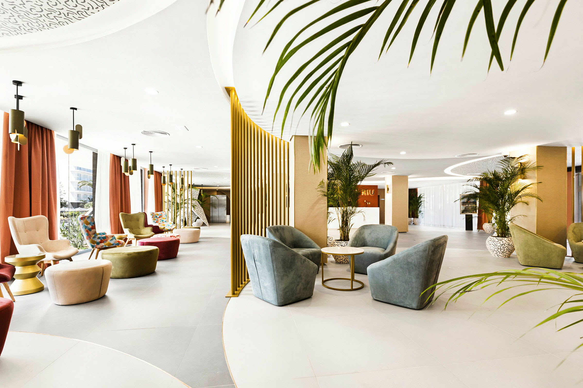 En åpen hotellobby med moderne møbler, planter og designlamper. (AI-generert tekst)