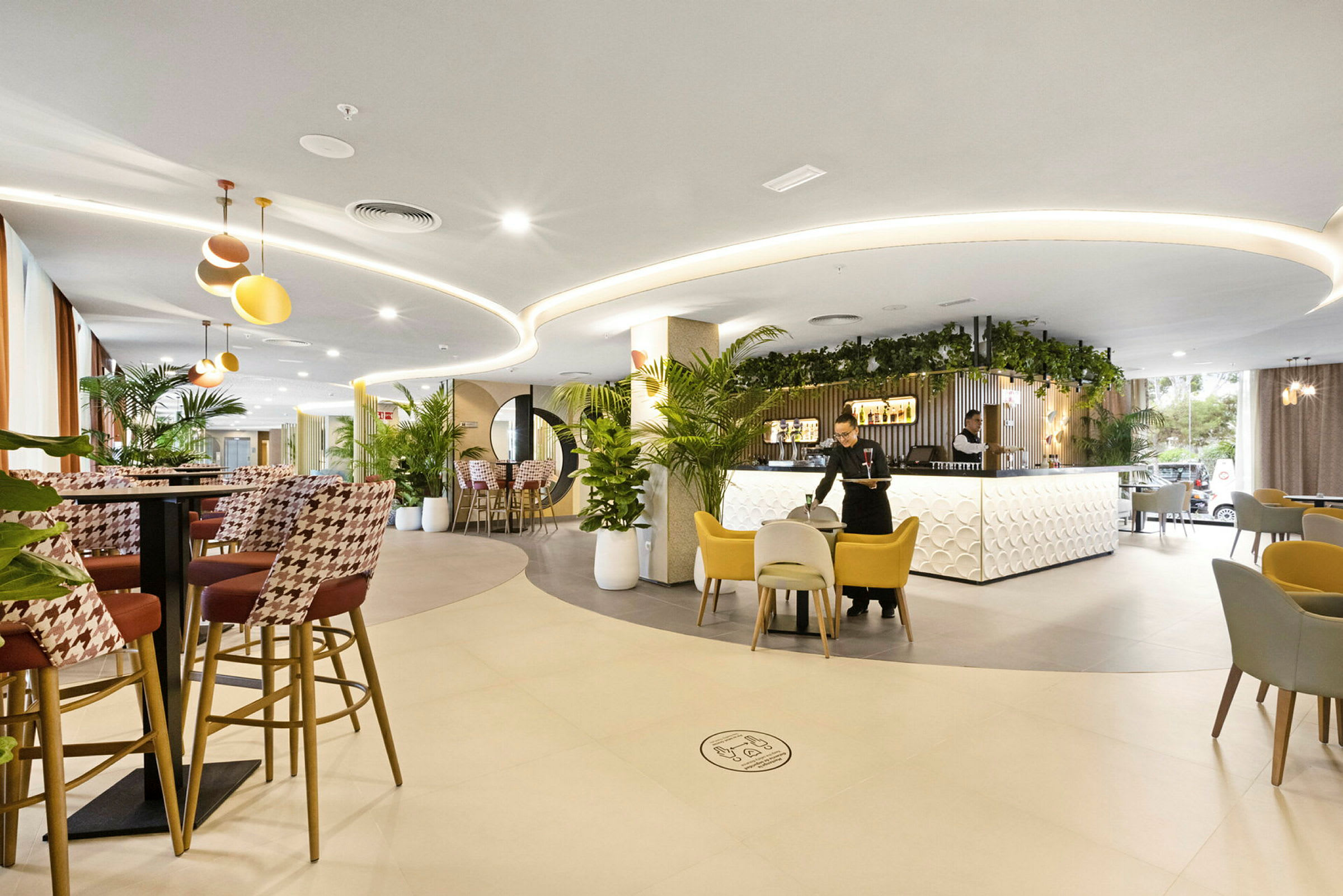 Et moderne hotellatrium med stilig innredning, sitteplasser og plantedekorasjoner. (AI-generert tekst)
