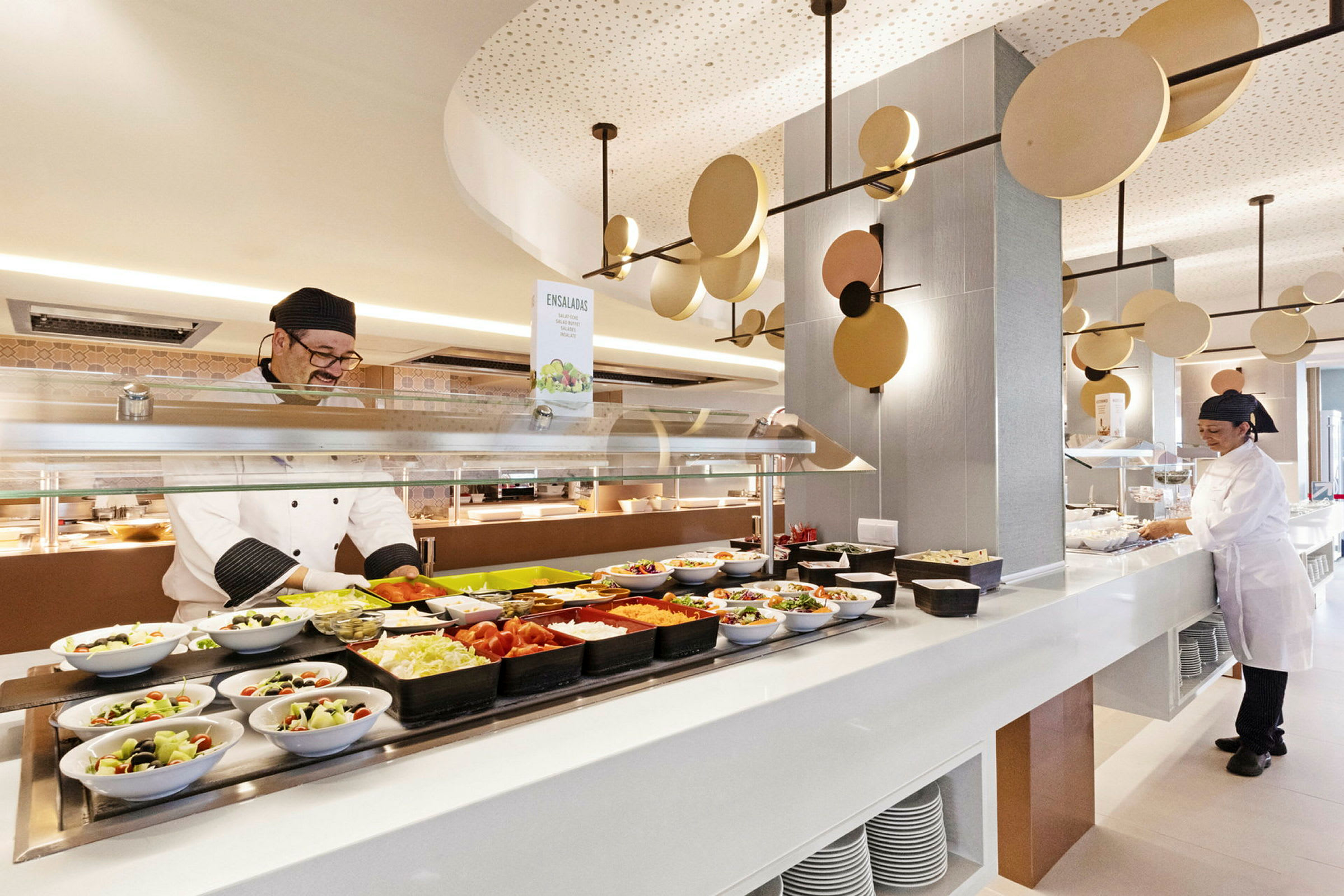Buffé med salater og tilbehør, servert i en lys og moderne restaurant. (AI-generert tekst)