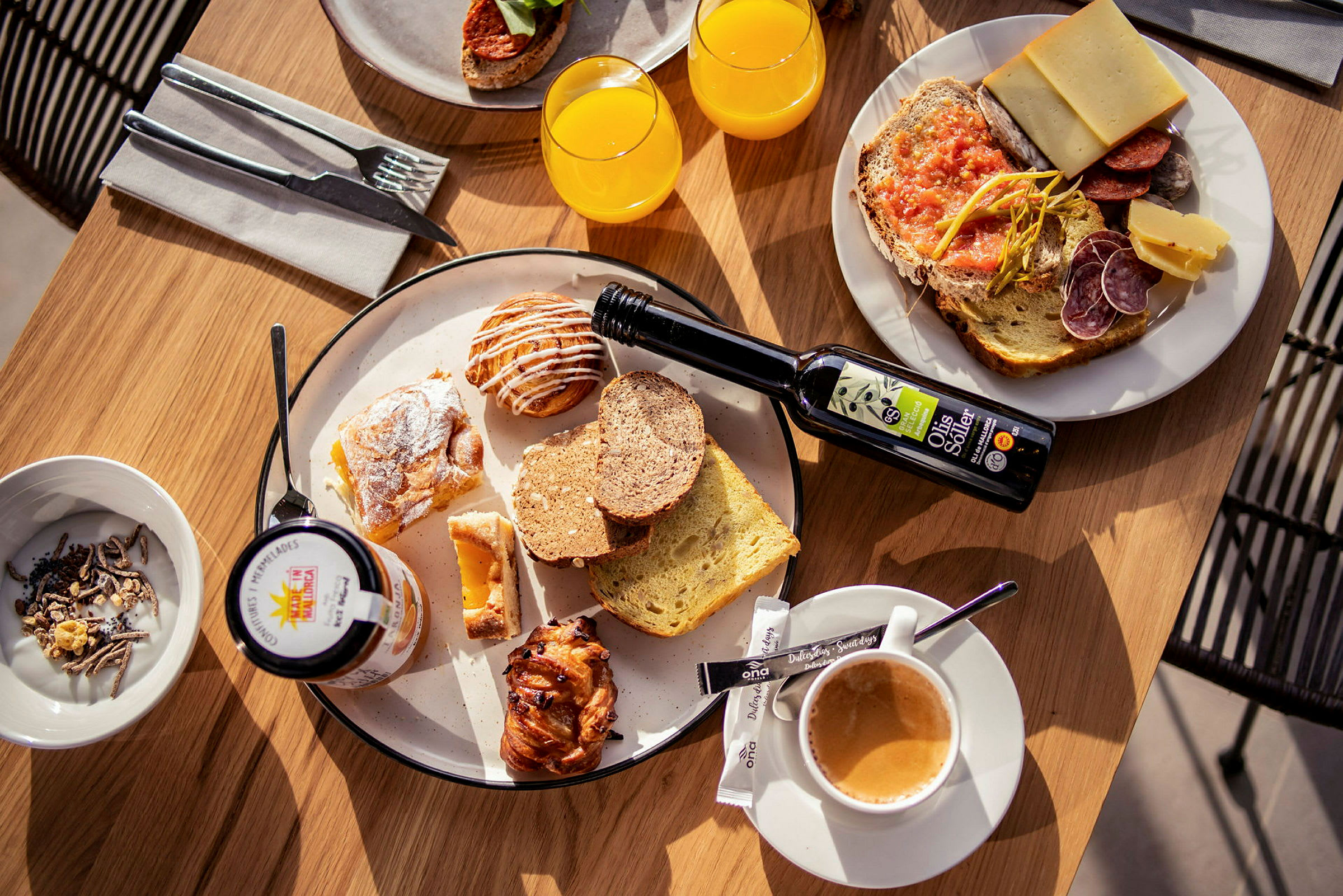 Et bord satt med en frokost som inkluderer brød, bakverk, juice, kaffe og pålegg. (AI-generert tekst)