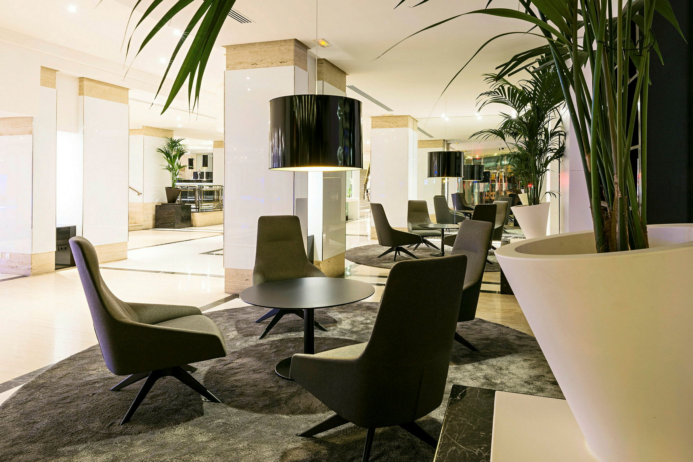 Interiør av et moderne loungeområde med sittegrupper og dekorative planter. (AI-generert tekst)