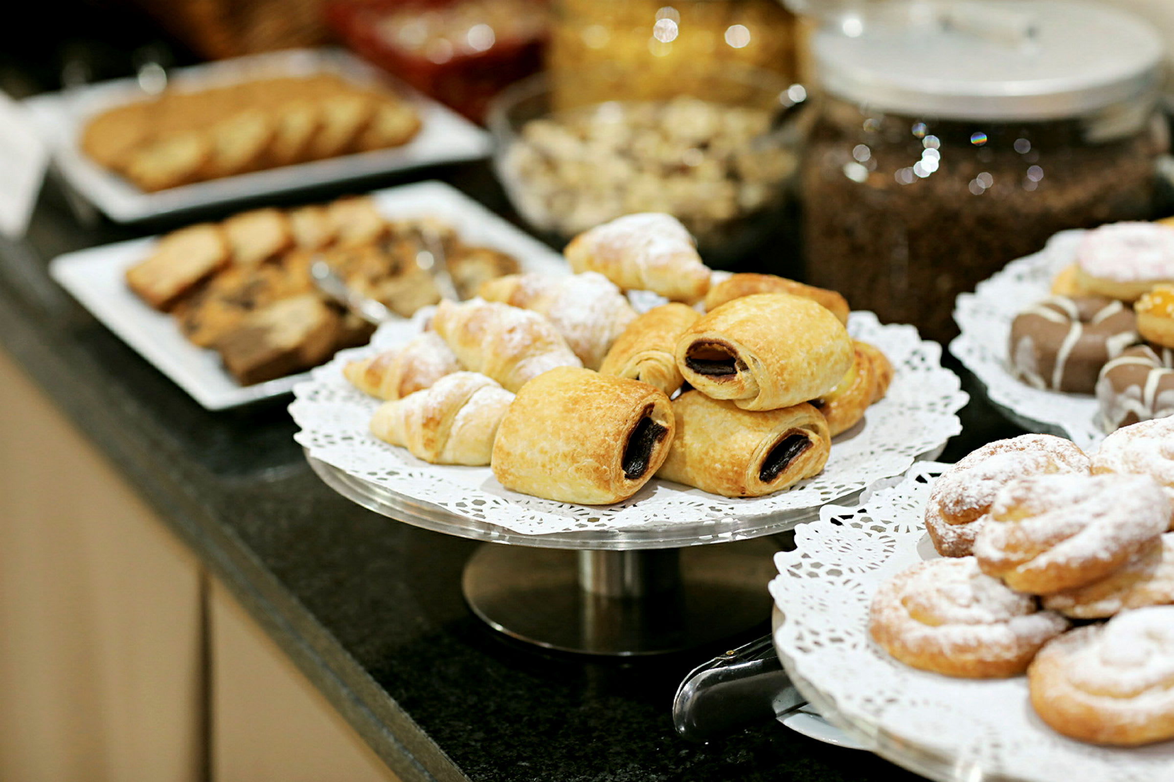 Et utvalg av bakevarer på tallerkener, inkludert croissanter og andre søte bakverk. (AI-generert tekst)