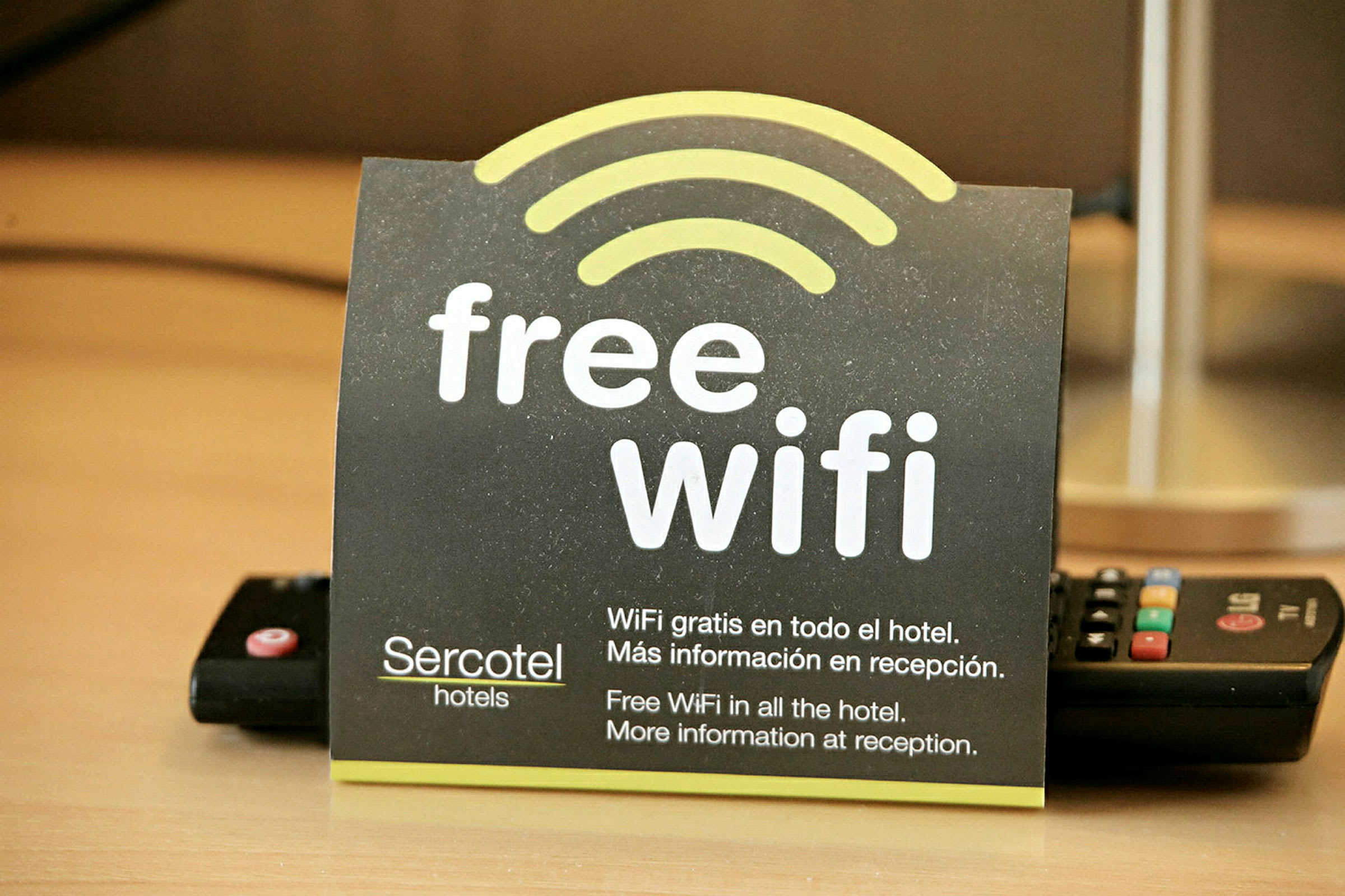 Et kort som informerer om gratis Wi-Fi på et hotell, med tekst på både engelsk og spansk. (AI-generert tekst)