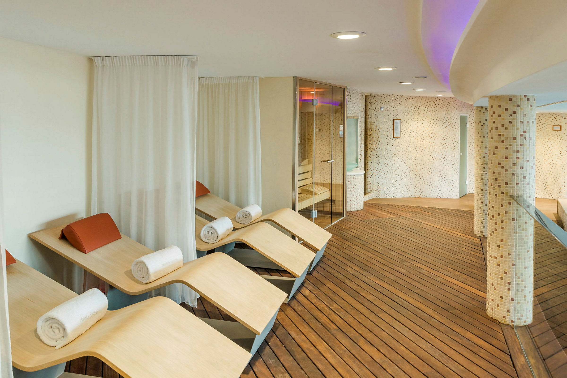 Moderne spa-avslapningsområde med trebenker og håndklær. (AI-generert tekst)