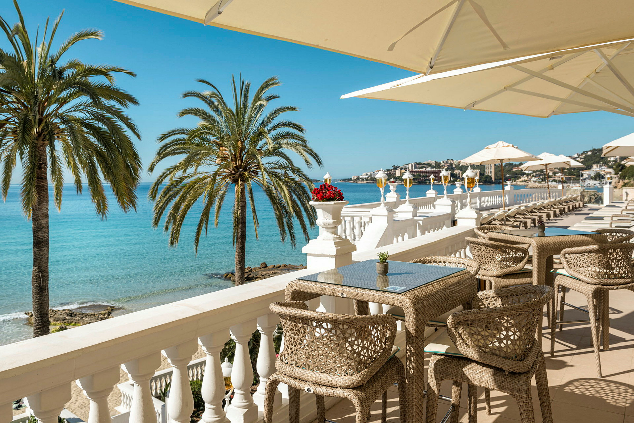 En terrasse med utsikt over havet, solsenger og parasoller. (AI-generert tekst)