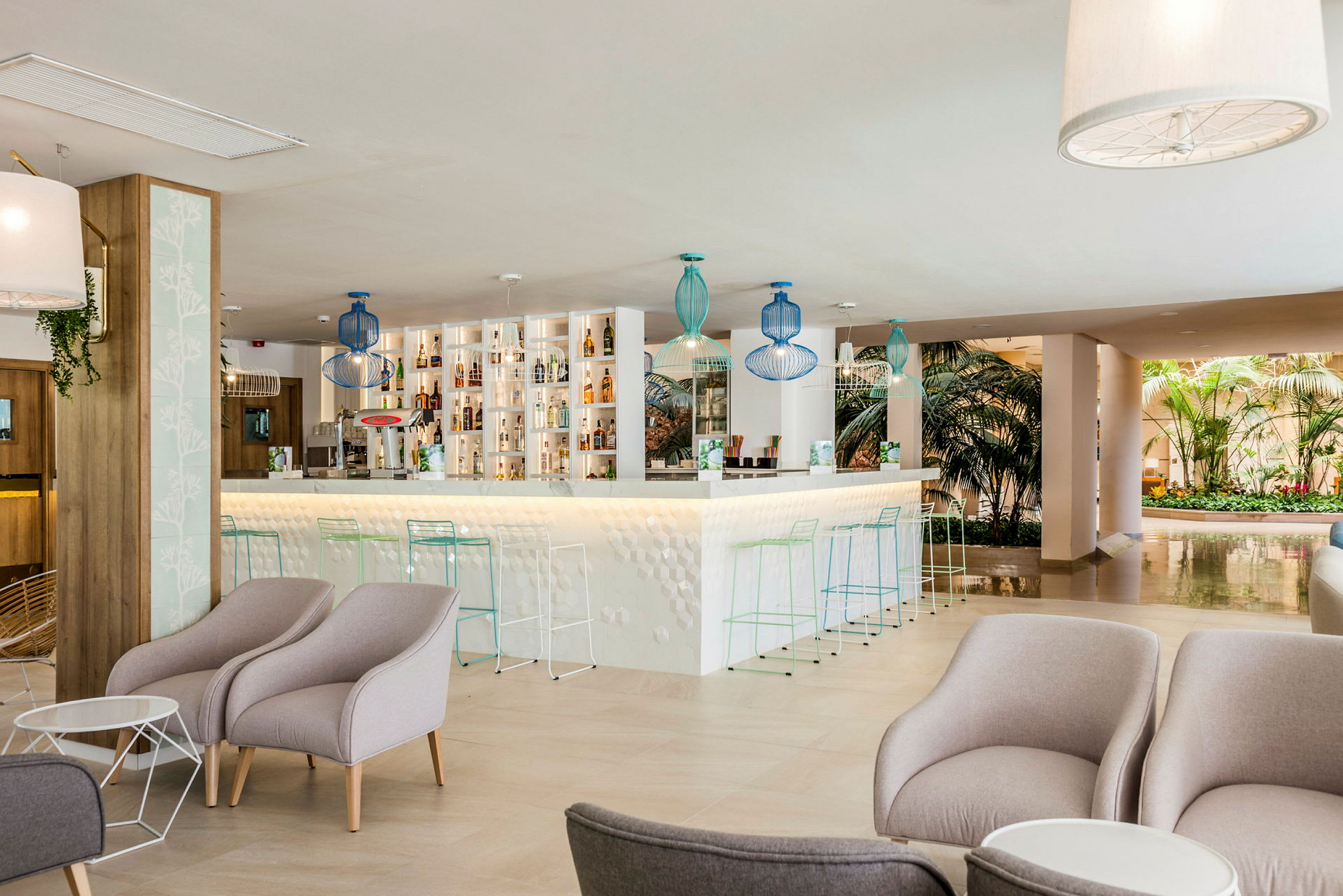 En elegant hotellbar med komfortable lenestoler og en moderne bardisk. (AI-generert tekst)