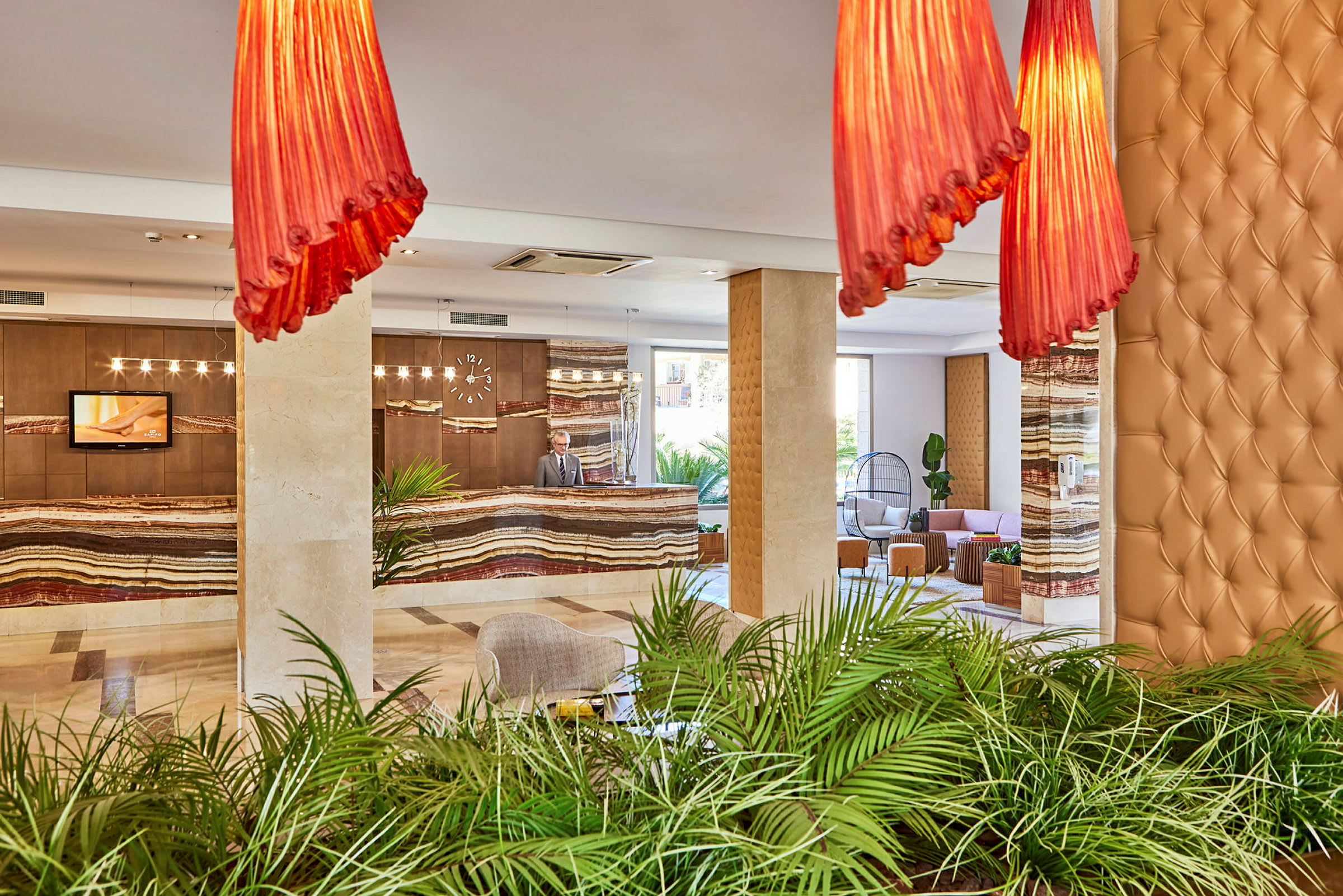 Hotellobby med resepsjon, grønne planter og sitteplasser. (AI-generert tekst)