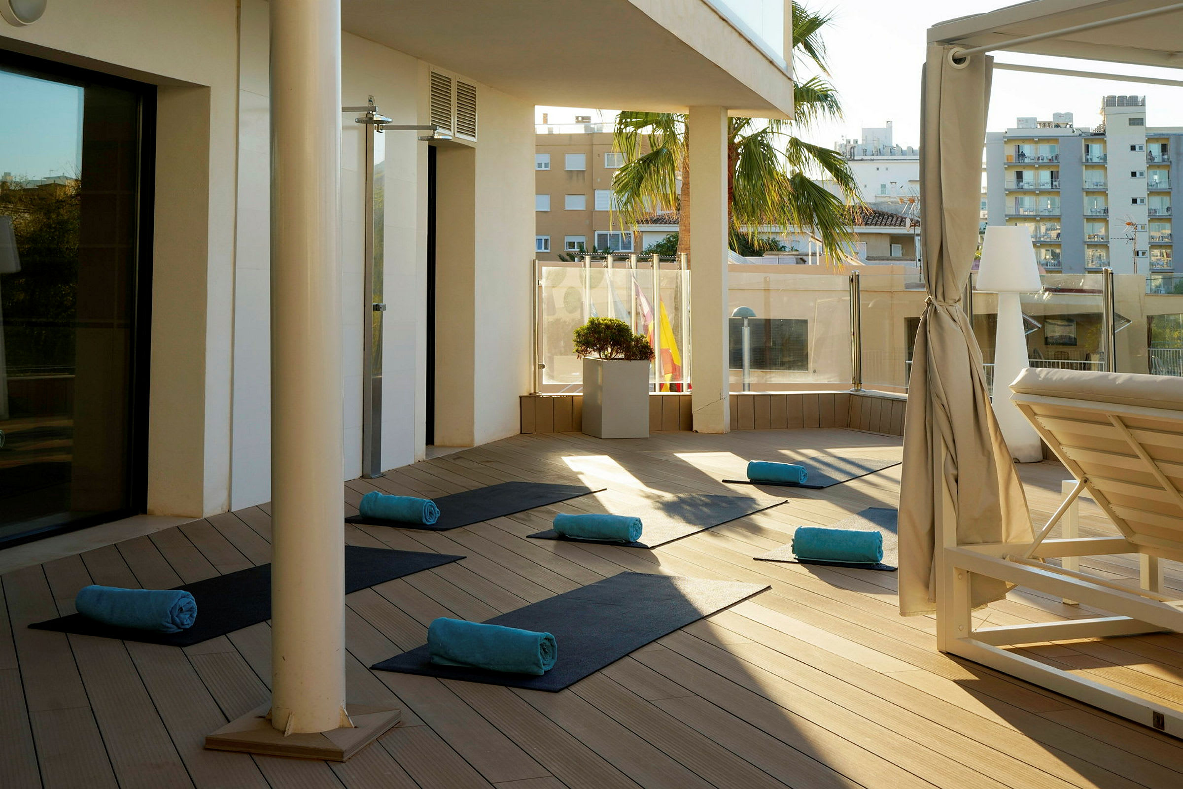 Solbelyst terrasse med utlagte yogamatter og håndklær. (AI-generert tekst)
