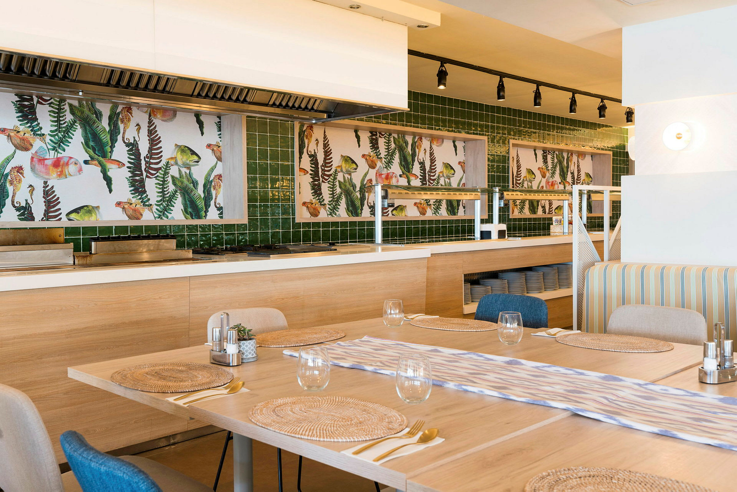 En restaurantinteriør med oppdekkede bord og kunstverk på veggen bak. (AI-generert tekst)