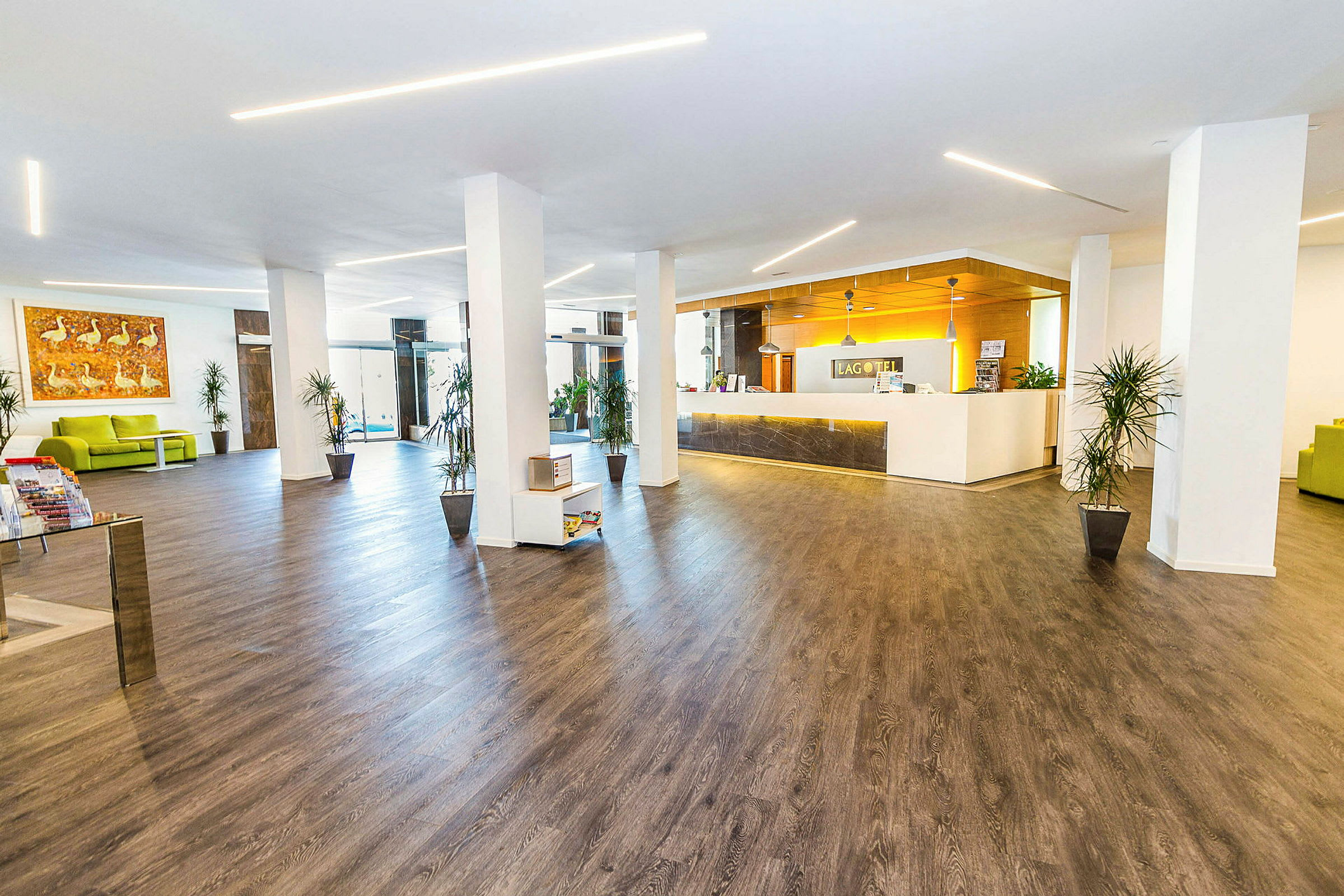 Bilde av et hotellobby med moderne interiør, tregulv og en resepsjonsdisk. (AI-generert tekst)