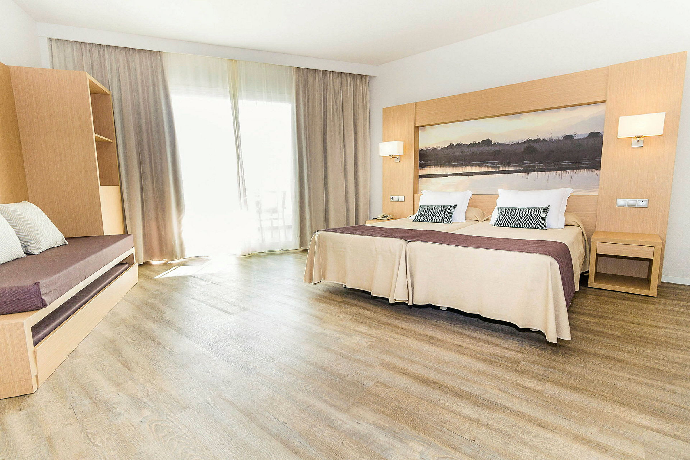 Hotellrom med to enkeltsenger, en sittemøbel og store gardiner. (AI-generert tekst)