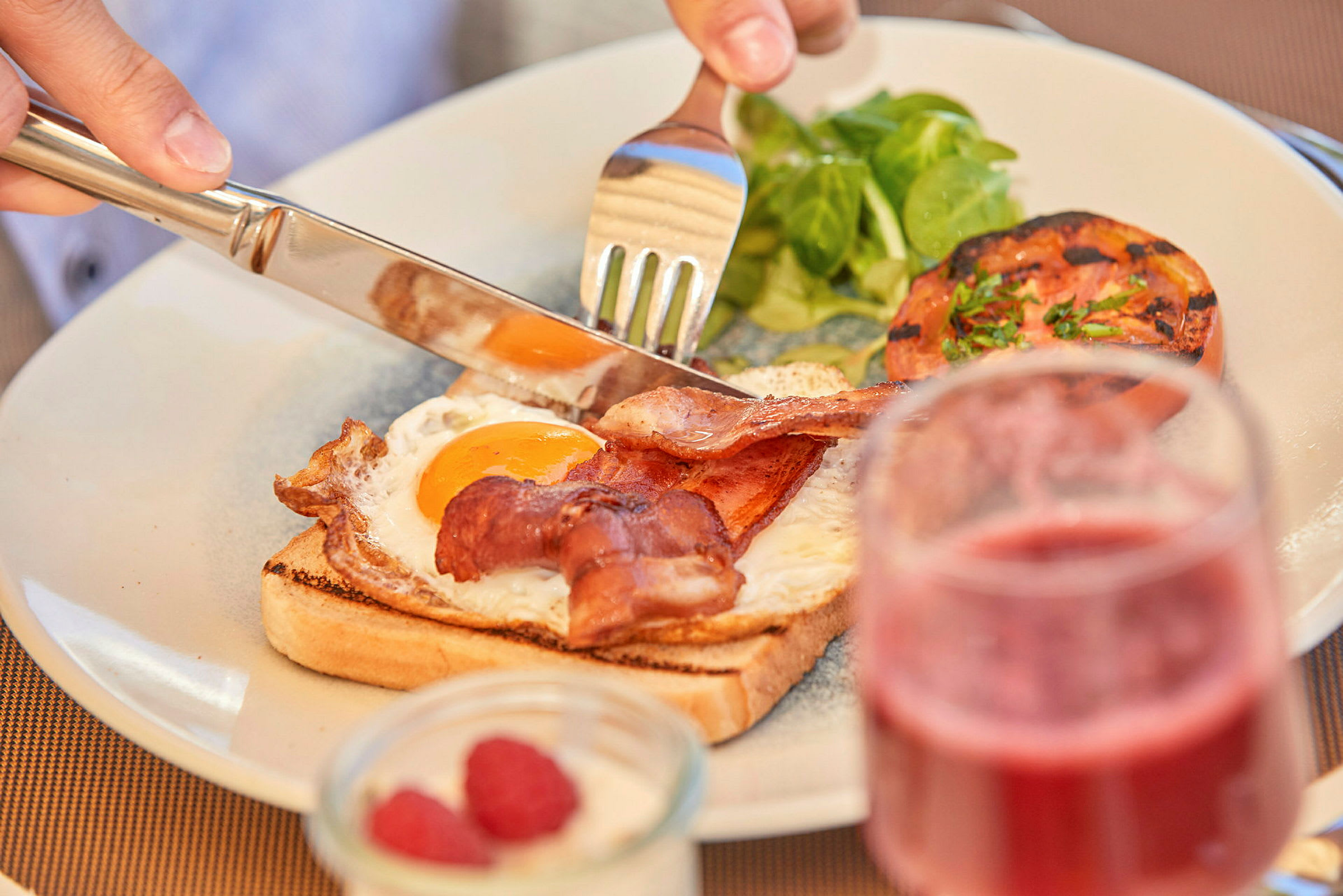 Tallerken med bacon, stekt egg og grønt. (AI-generert tekst)