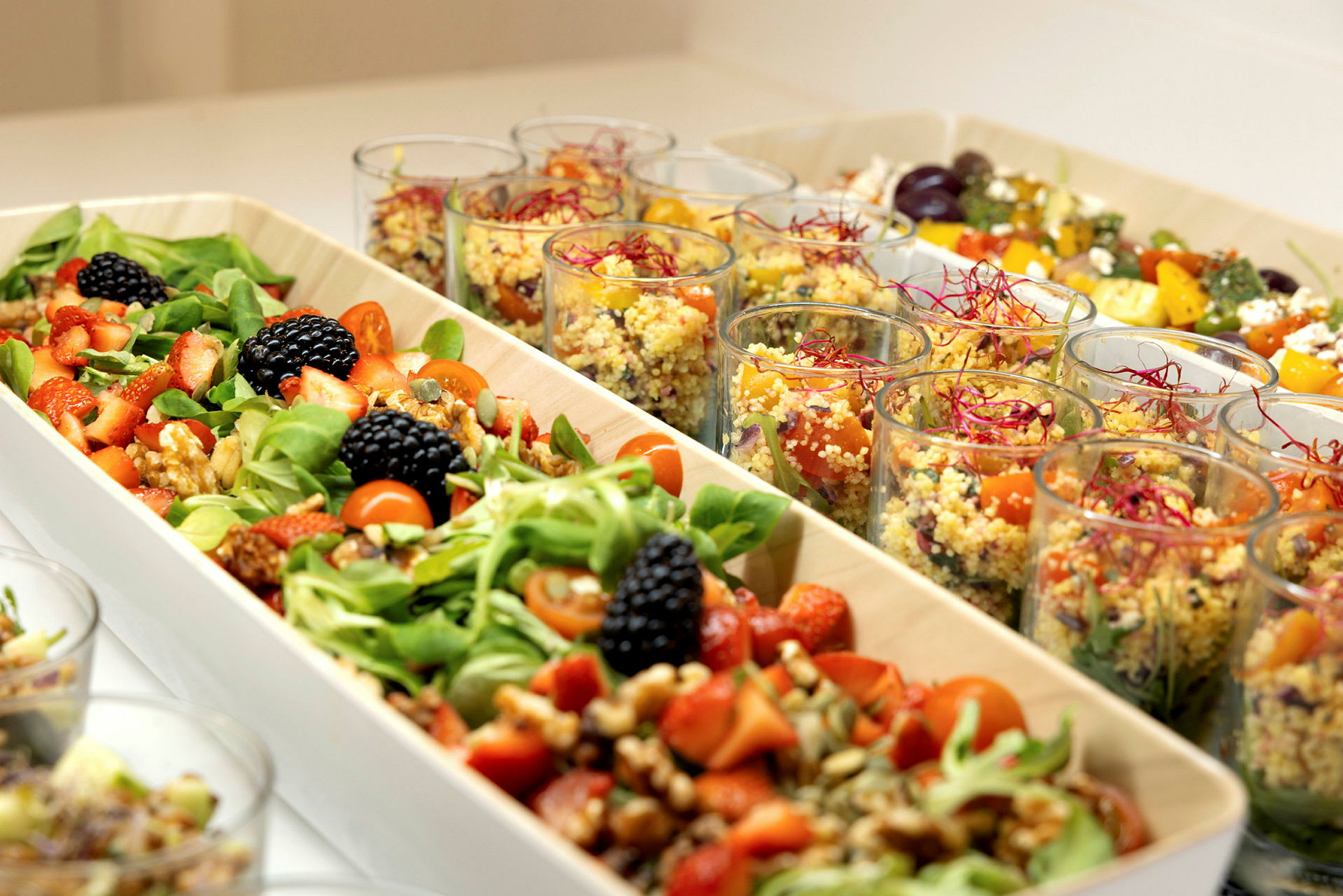 En buffet med salat og quinoa servert i boller og glass. (AI-generert tekst)