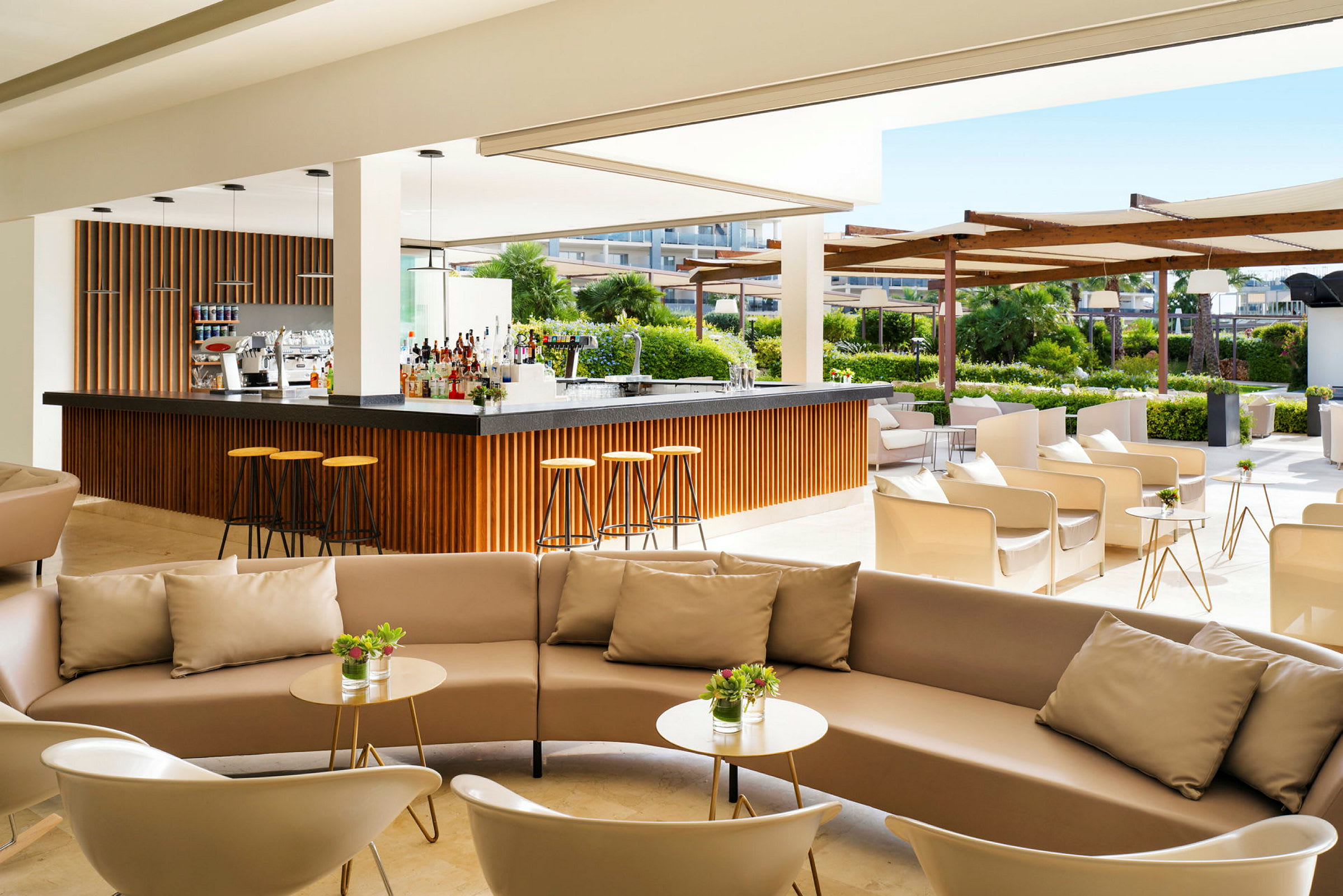 Moderne utendørs bar med komfortable sittegrupper og grønt i bakgrunnen. (AI-generert tekst)