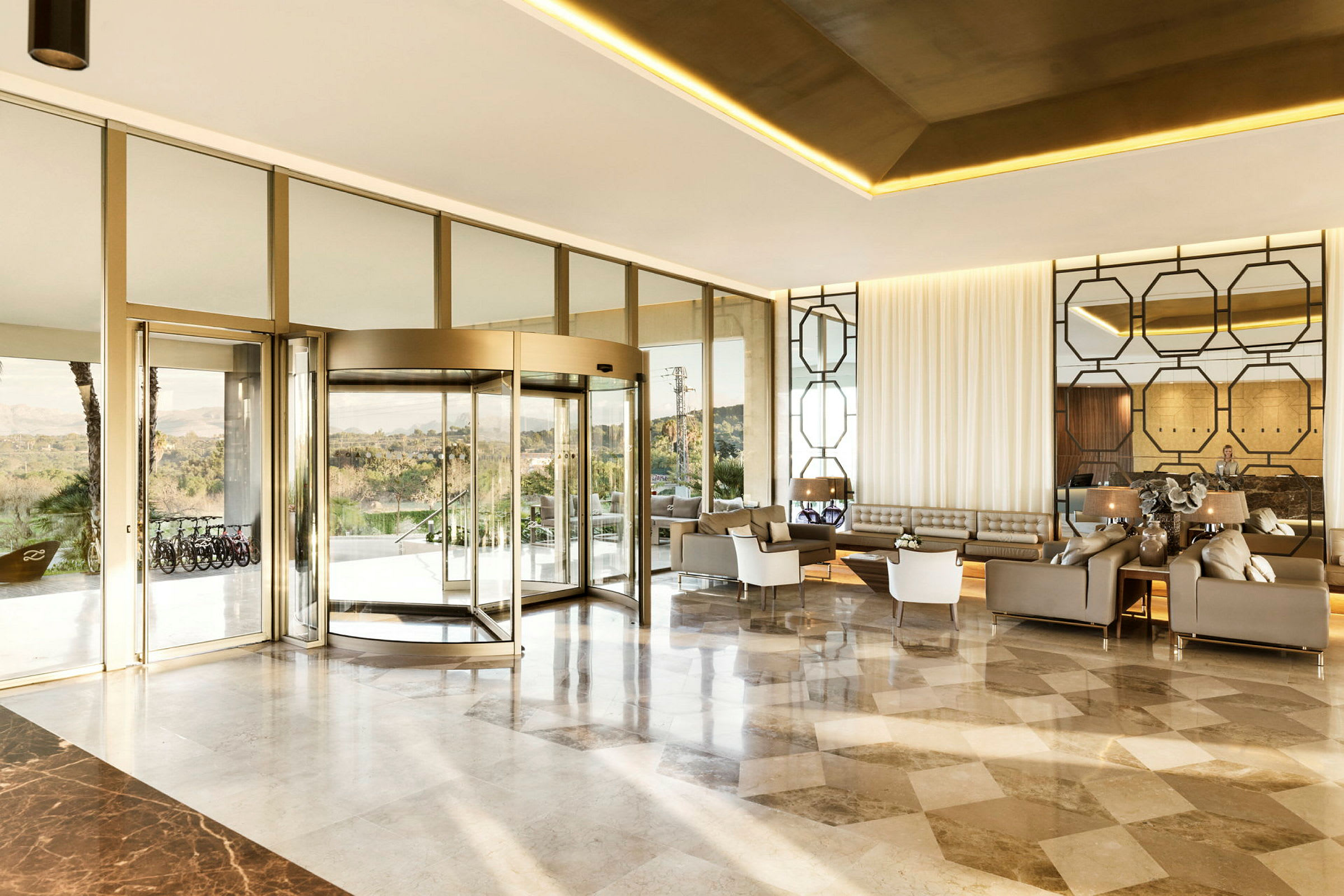 En moderne hotellobby med en glassvegg og karuselldør. (AI-generert tekst)