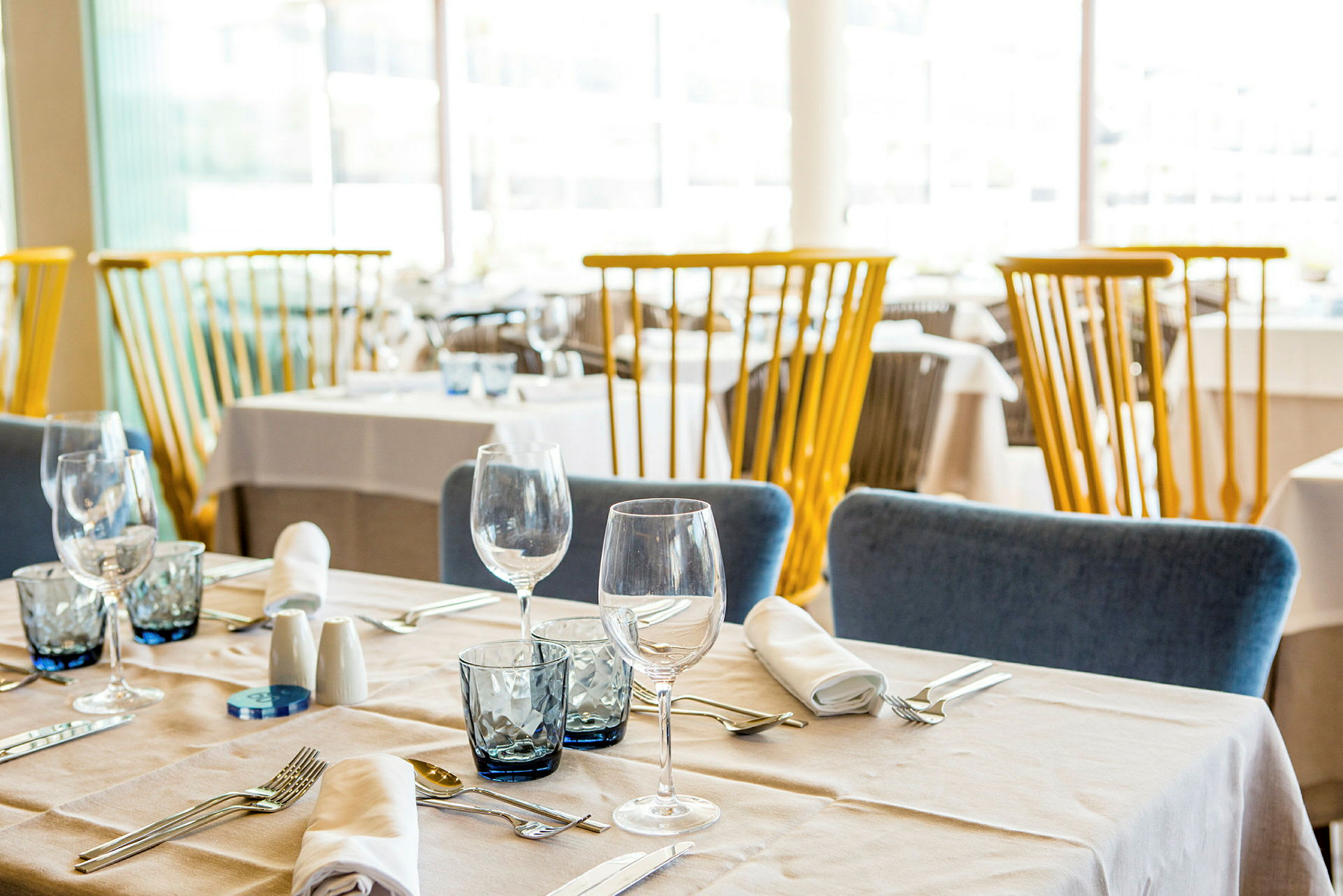 Innredet restaurant med dekkede bord og stoler. (AI-generert tekst)