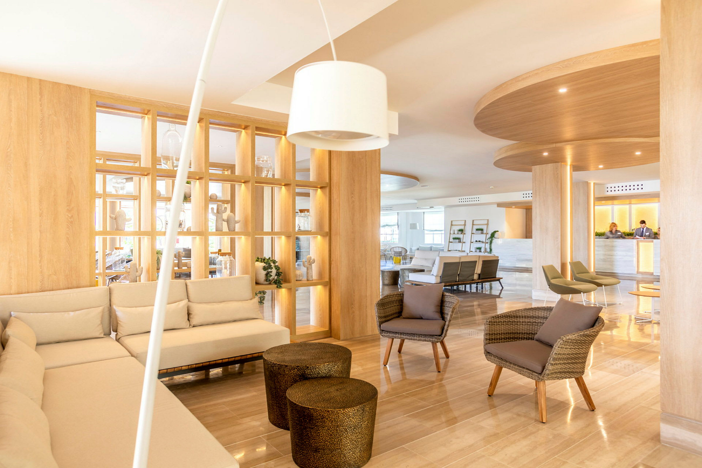 Et lyst og moderne hotellobbyområde med sofaer, lenestoler og dekorative hyller. (AI-generert tekst)
