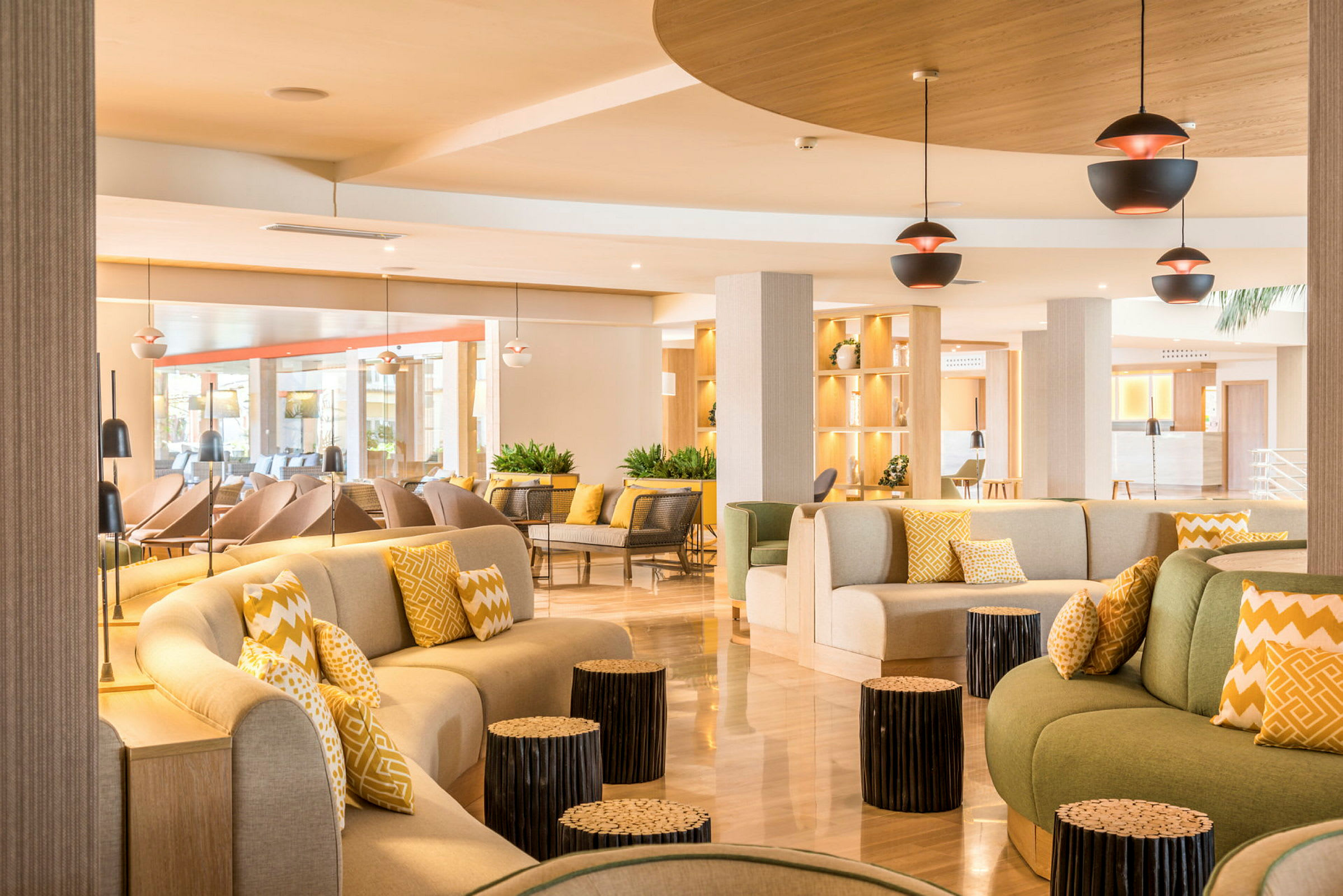 Interiør av en godt opplyst hotellobby med moderne sittemøbler og dekorative puter. (AI-generert tekst)
