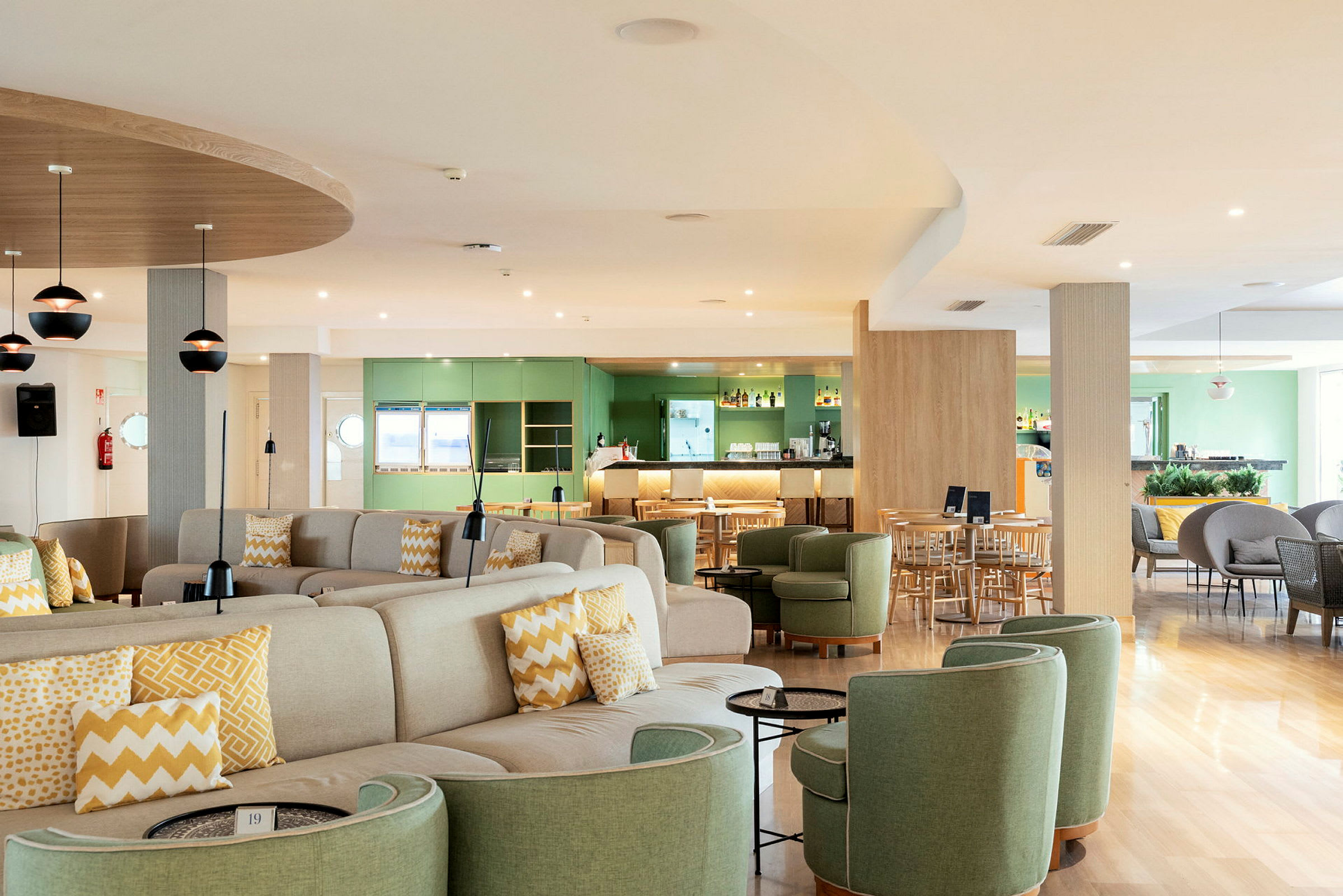 Restaurant med sittegrupper og barområde, lys farger og moderne interiør. (AI-generert tekst)
