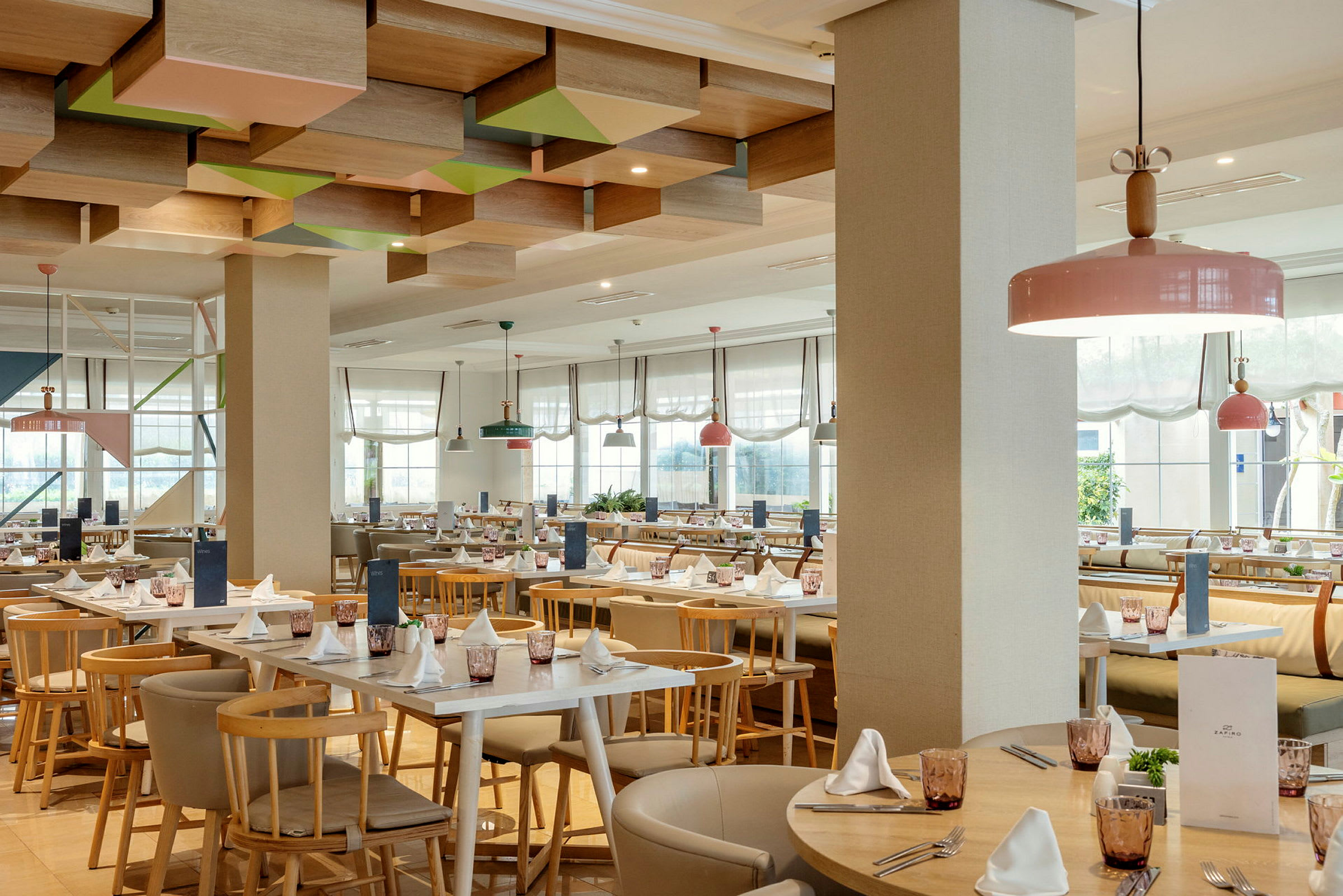 Restaurant med lyse møbler og dekorert tak. (AI-generert tekst)