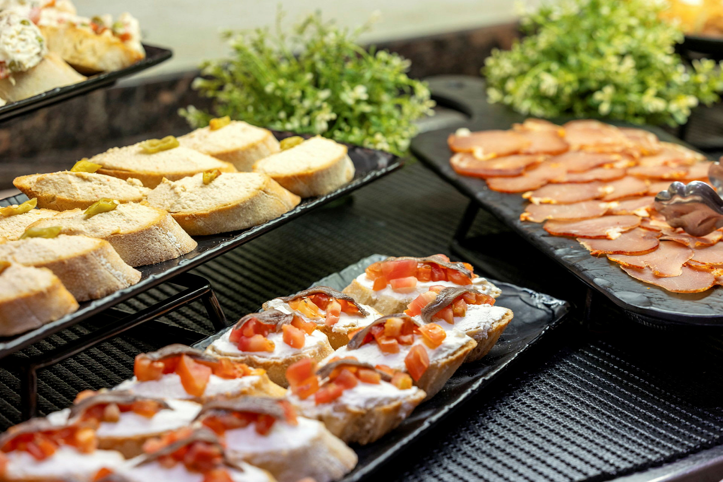 Smørbrød anrettet på fat sammen med pålegg på et bord. (AI-generert tekst)