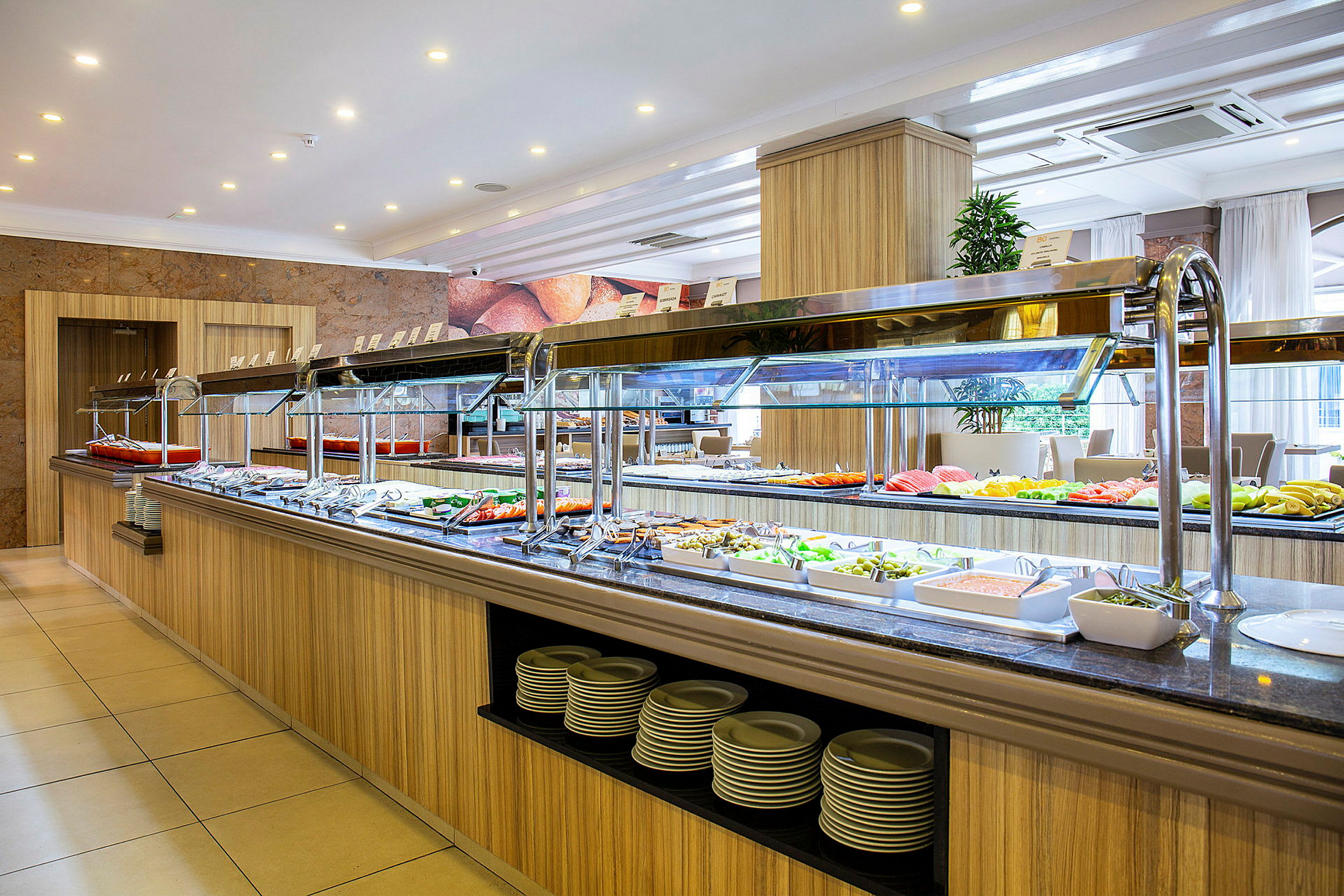 Selvbetjent buffet med ulike retter i en lys spisesal. (AI-generert tekst)