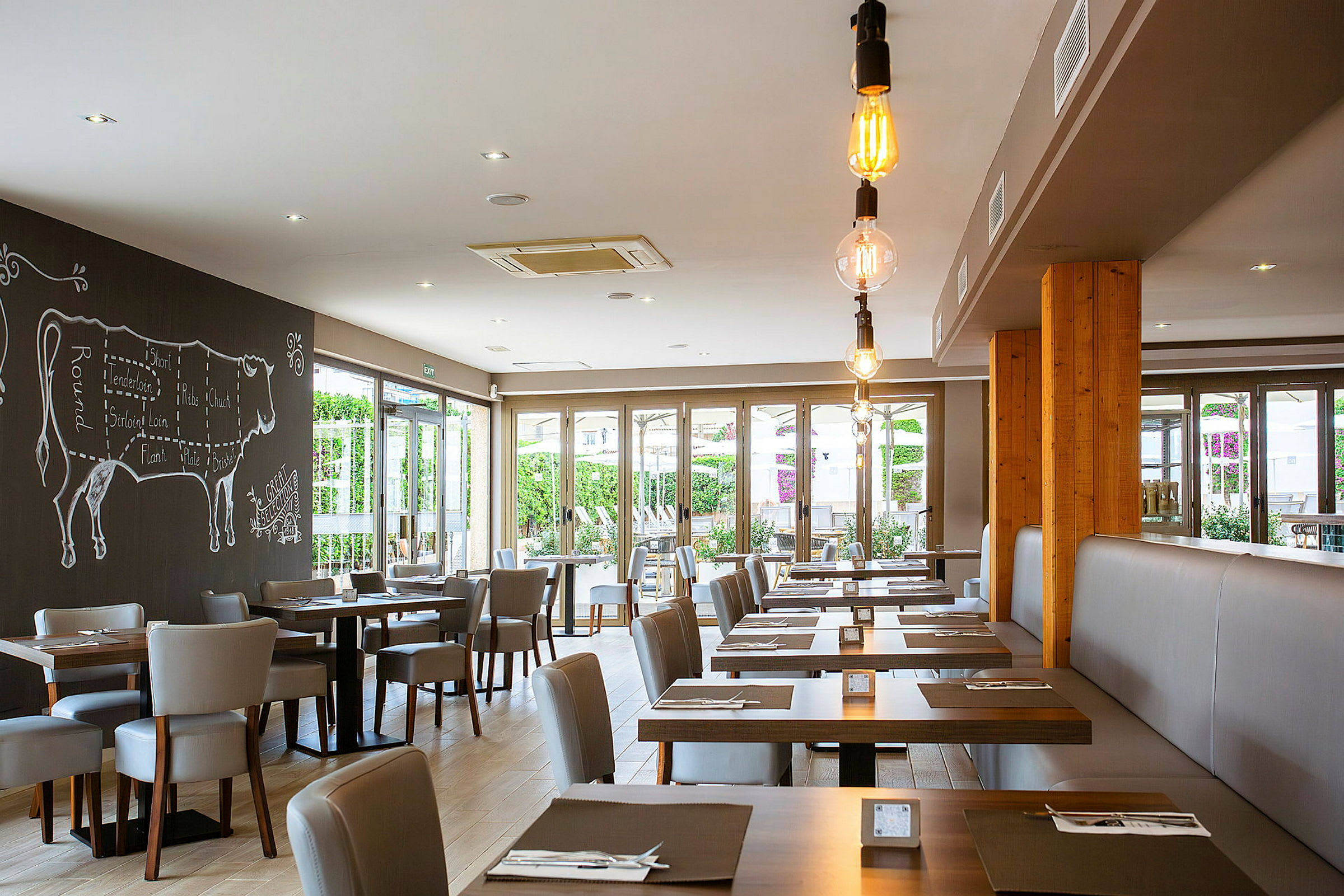 En moderne restaurant med bord og stoler, dekorert med en veggmaleri av en ku. (AI-generert tekst)