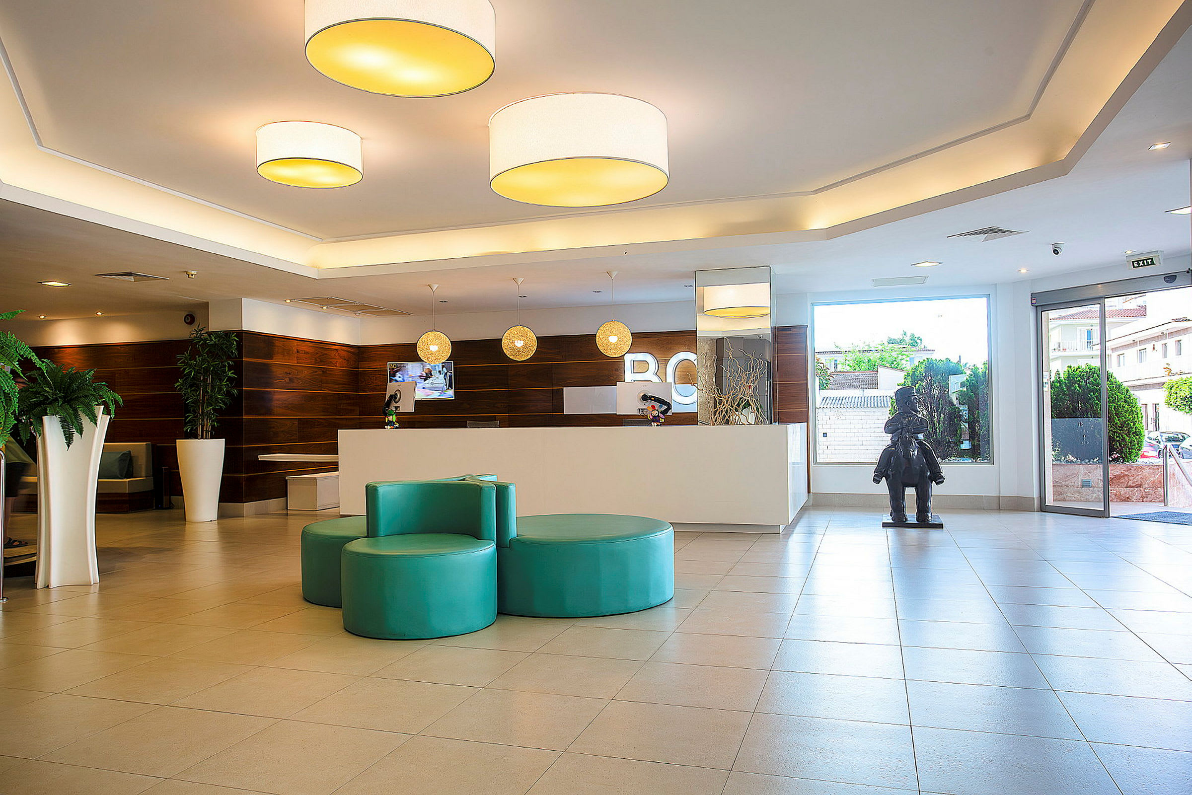 Hotellobby med resepsjon, sittemøbler og en vindusdør. (AI-generert tekst)