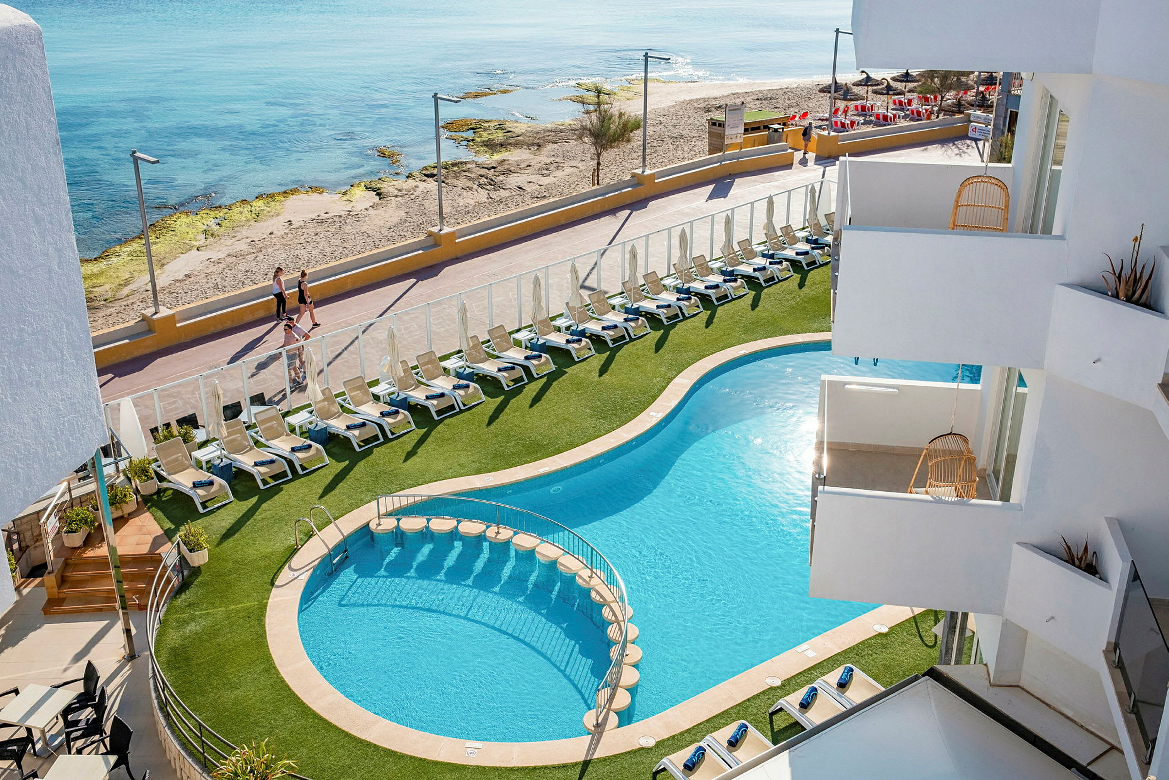 Hotellbasseng med solsenger og nærhet til strand og gangvei. (AI-generert tekst)