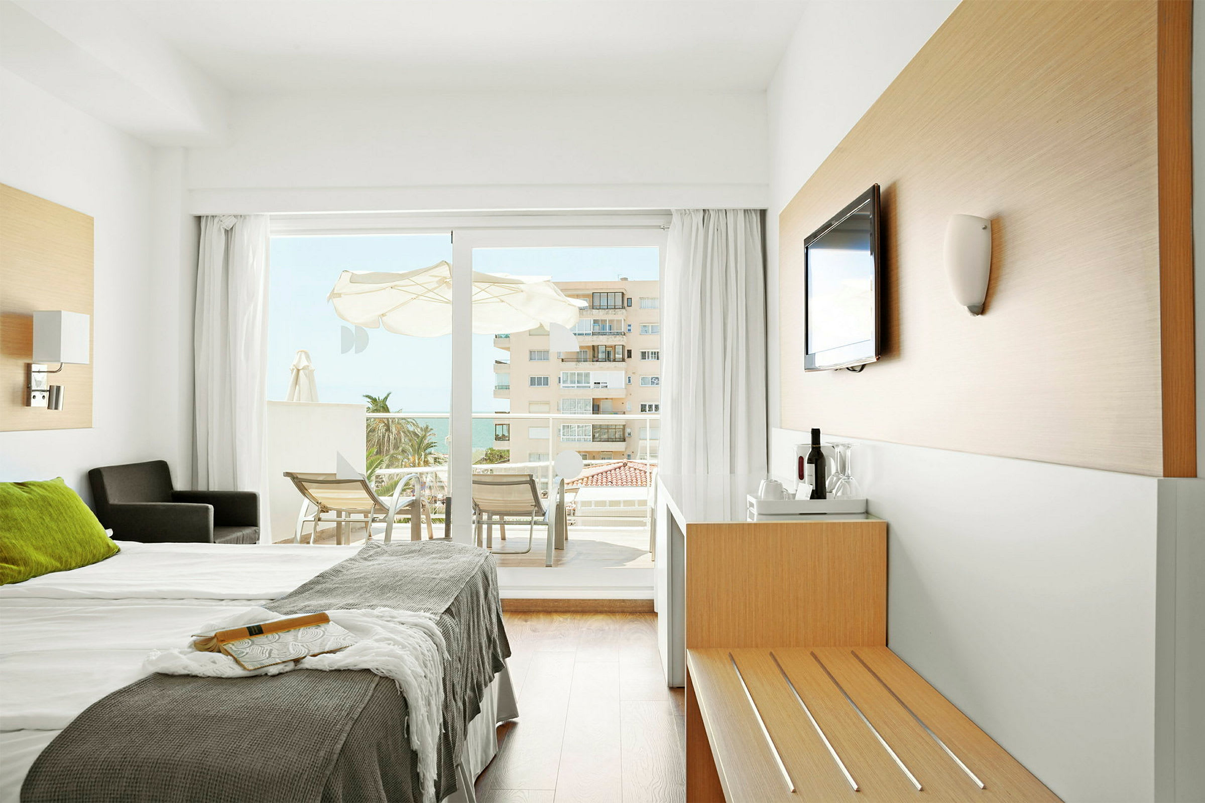 Moderne hotellrom med dobbeltseng og utsikt mot balkong. (AI-generert tekst)