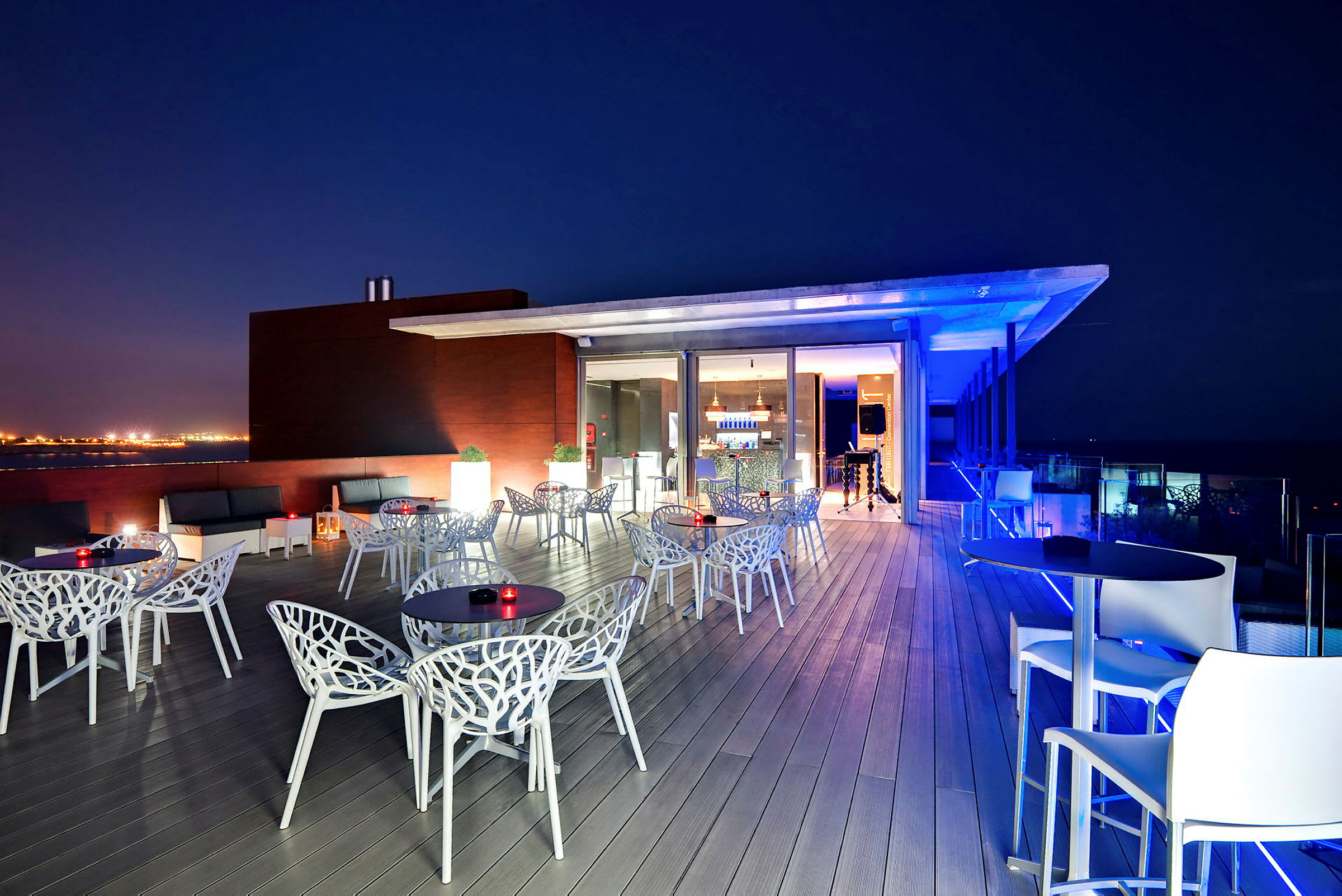 Takterrasse om natten med moderne møbler og belysning. (AI-generert tekst)
