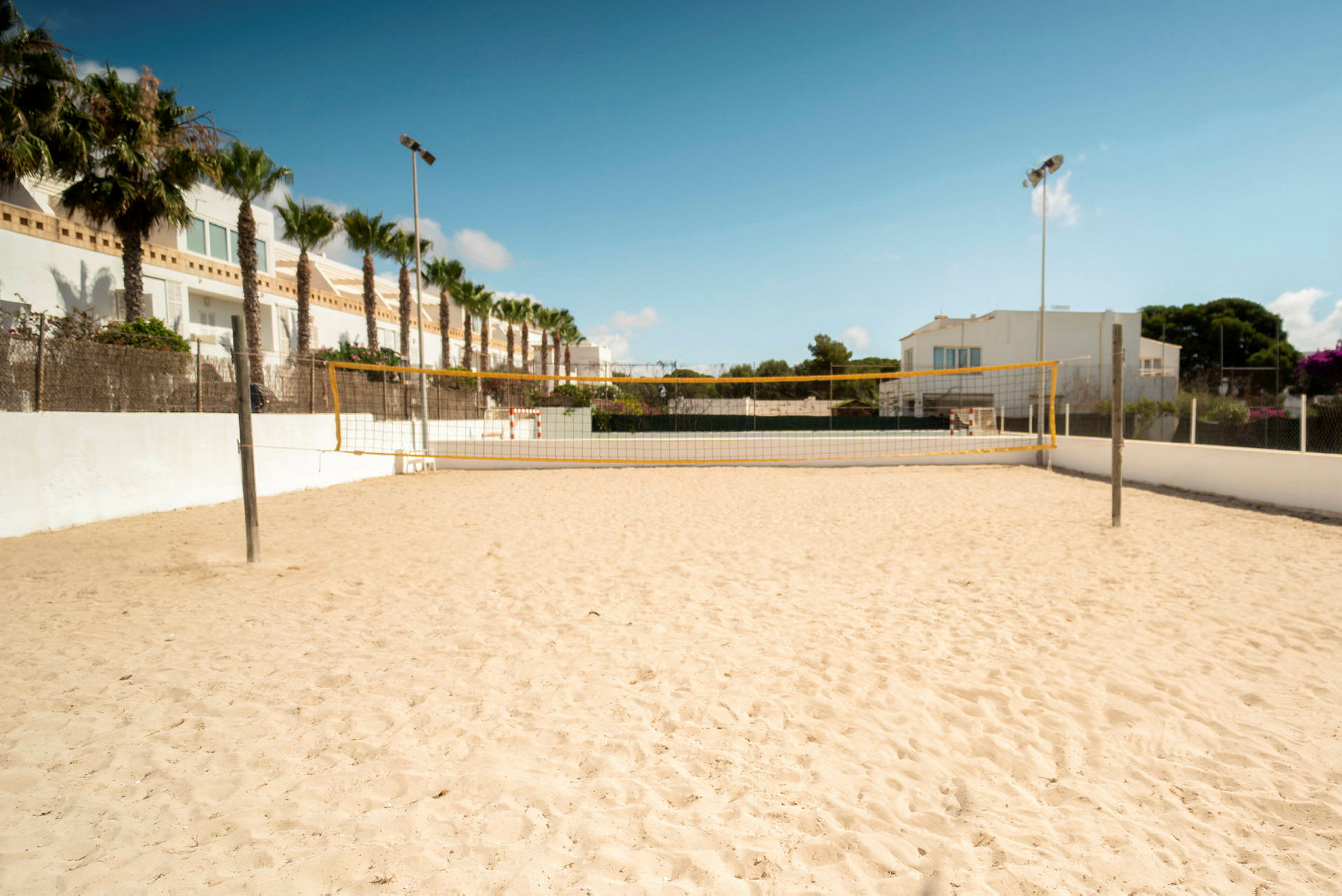 Sandbane med et volleyballnett utendørs. (AI-generert tekst)