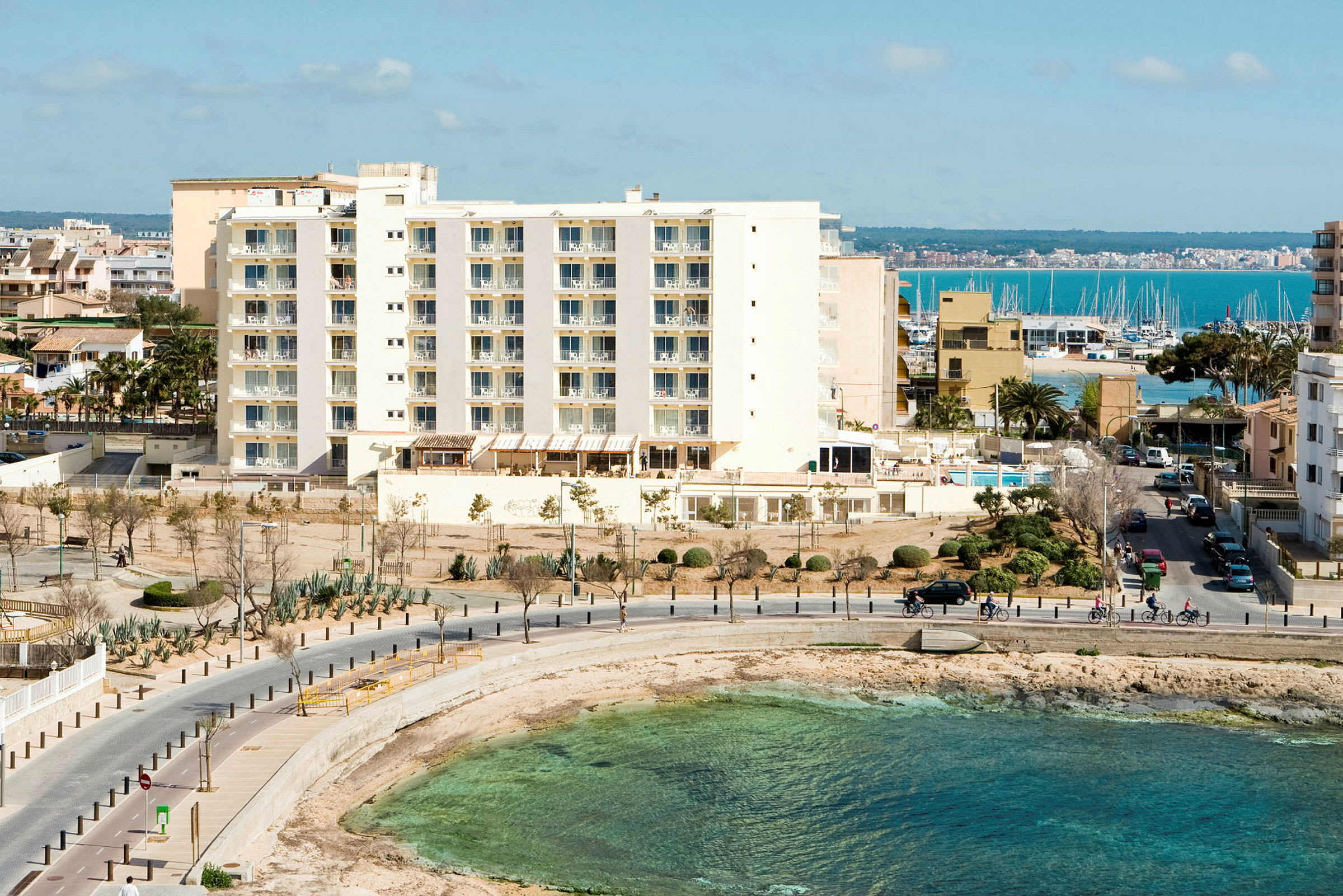 Et hotell ved stranden med utsikt over havet. (AI-generert tekst)