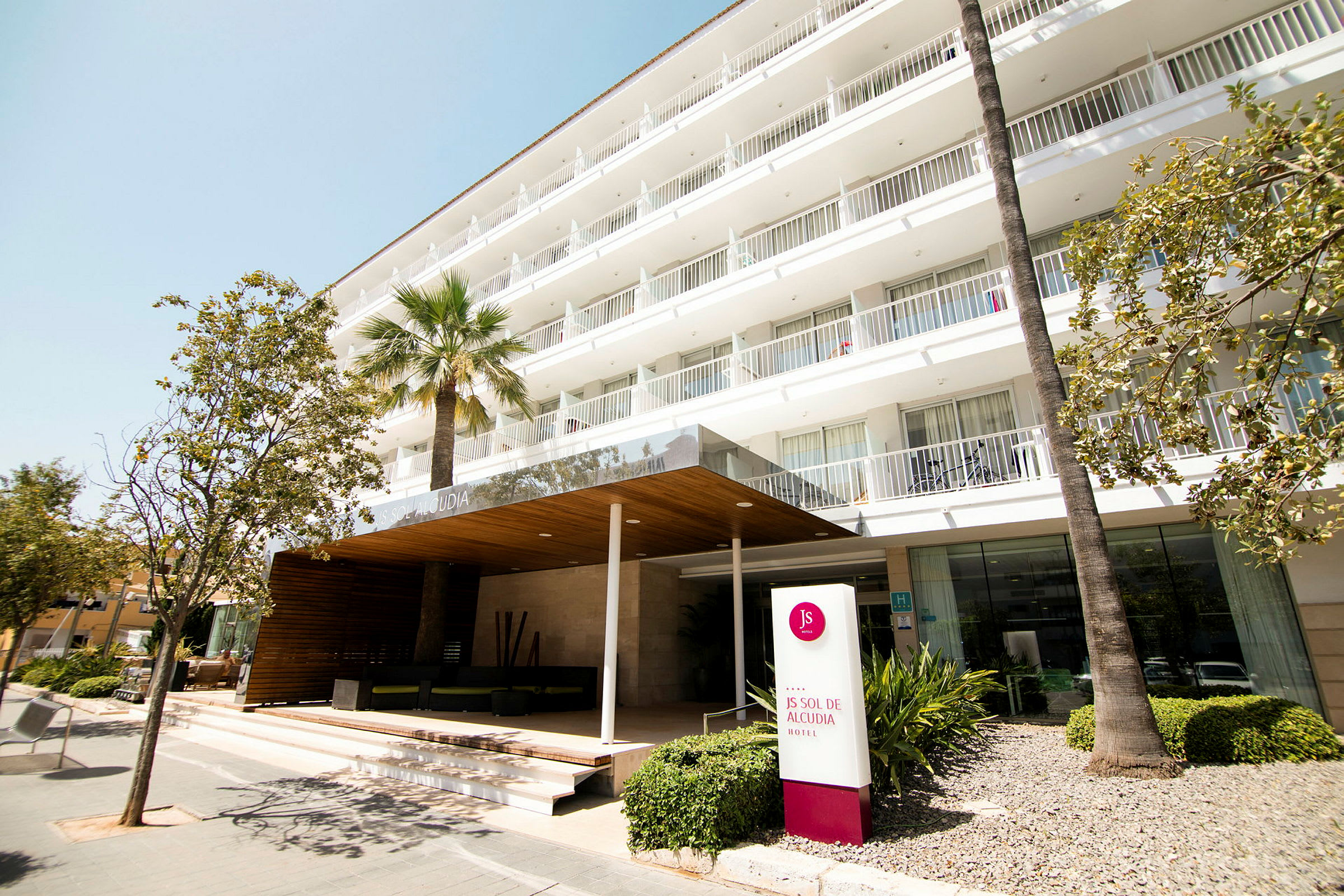 Hotellinngang med skilt som viser 'JS Sol de Alcudia'. (AI-generert tekst)