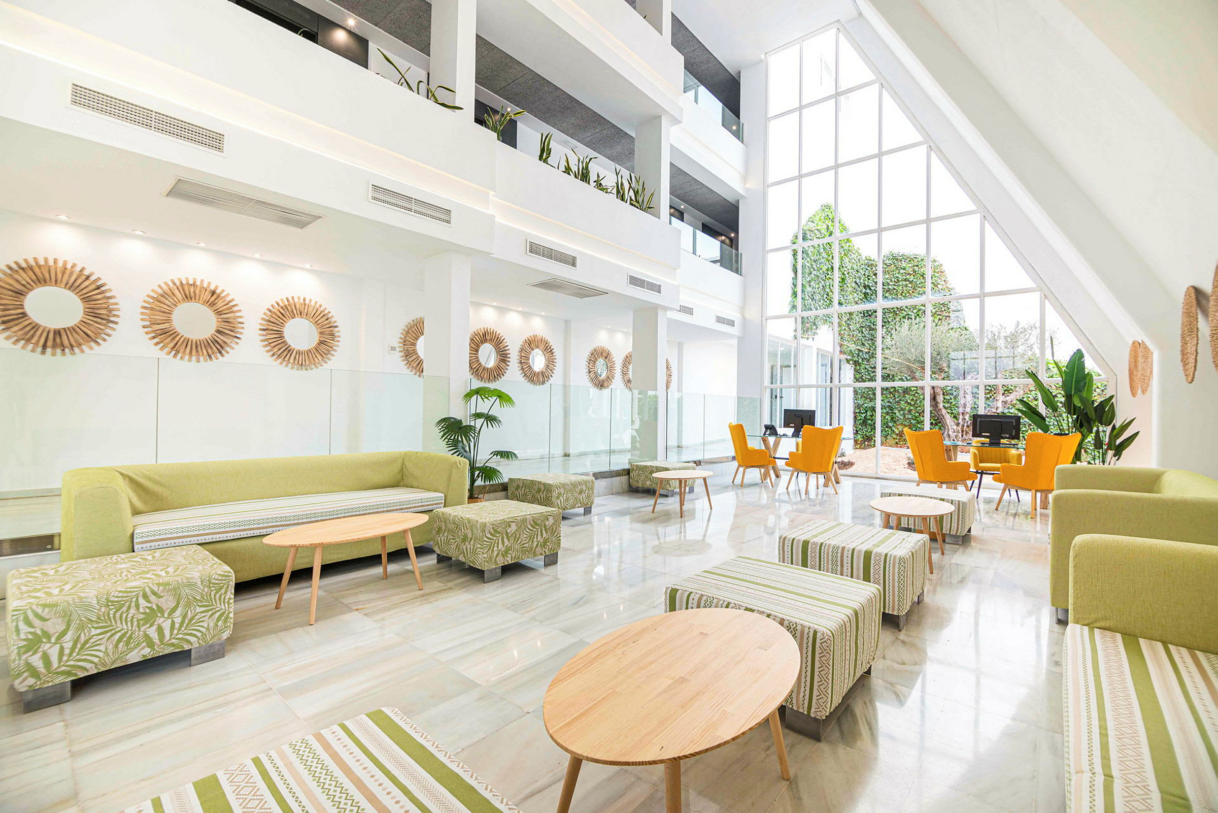 Moderne innredet hotellfoaje med store vinduer og grønne innslag. (AI-generert tekst)