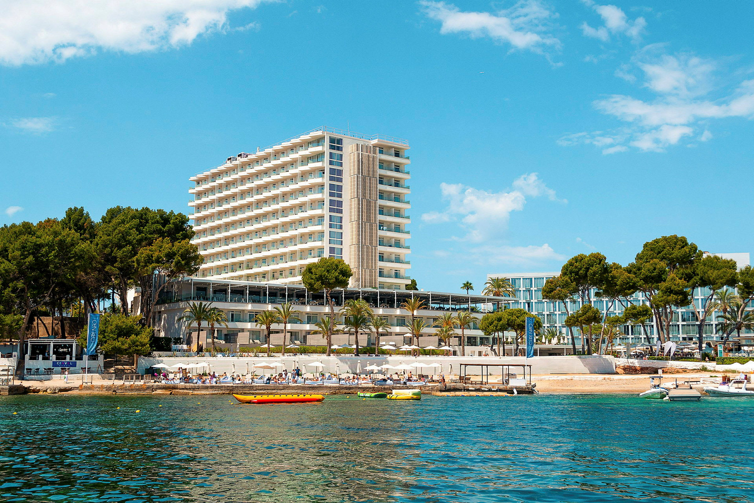 Høyt hotell ved stranden med blå himmel. (AI-generert tekst)