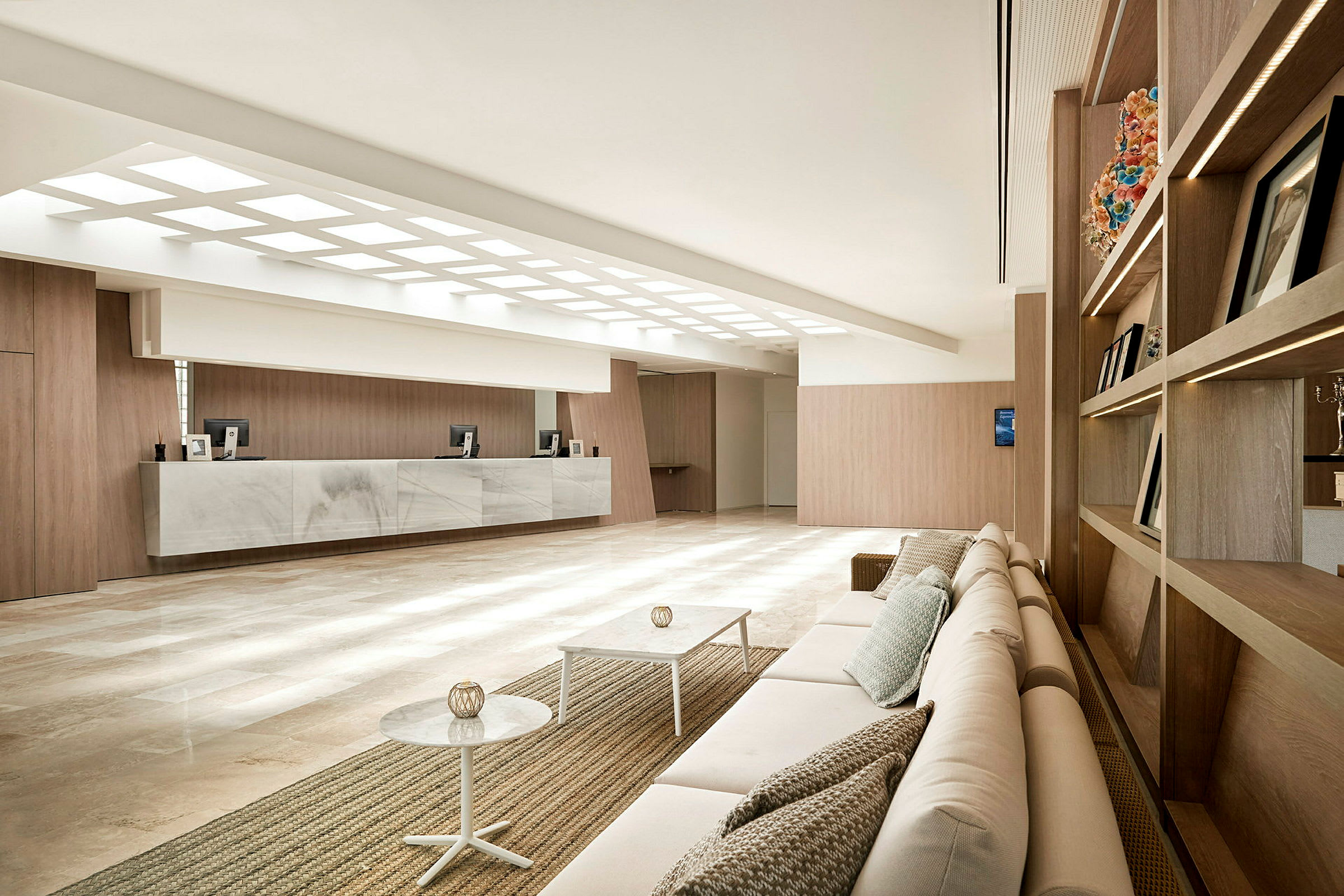 Bilde av en moderne hotellobby med en sittegruppe, resepsjonsområde og minimalistisk innredning. (AI-generert tekst)