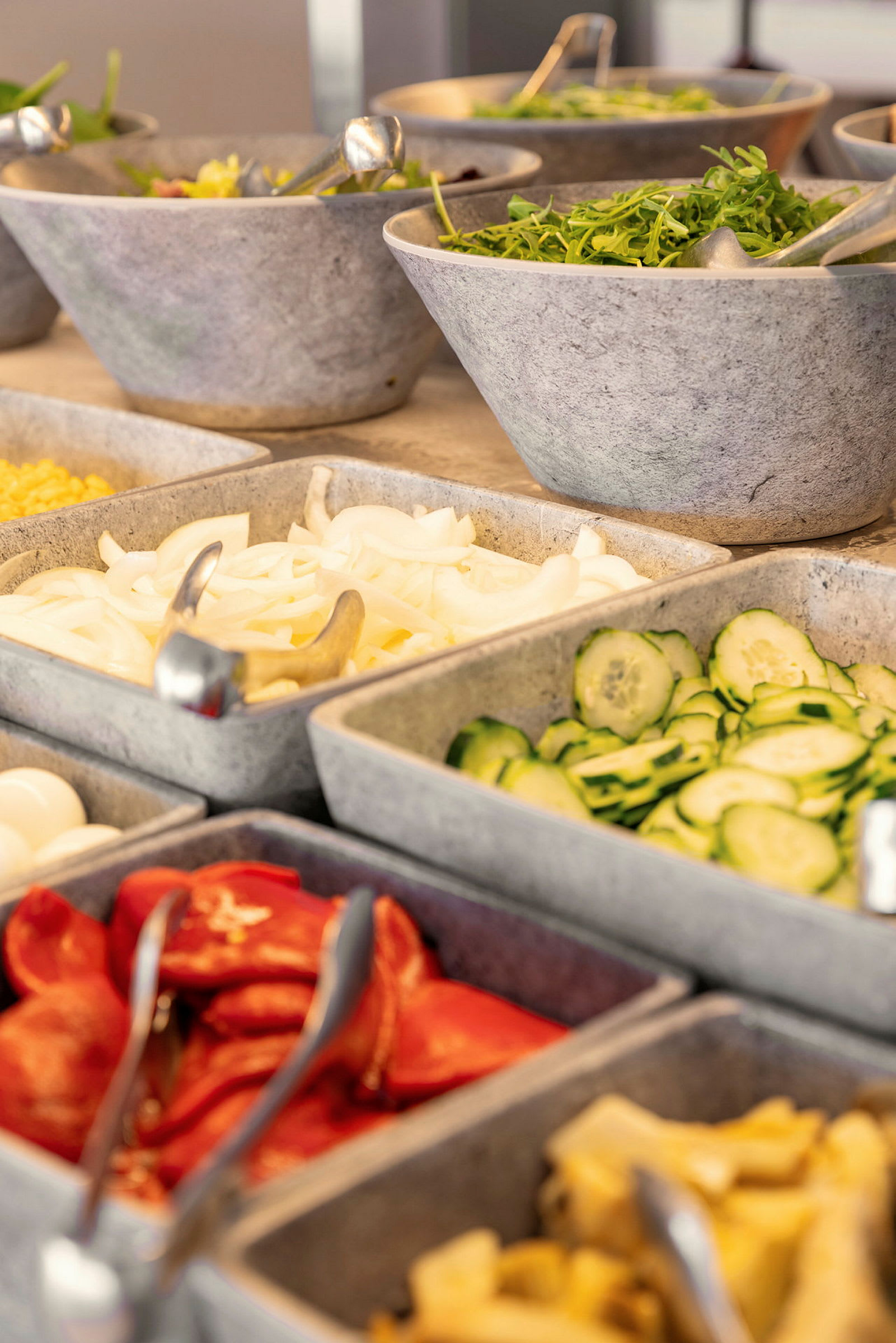 En salatbuffet med forskjellige grønnsaker og tilbehør i skåler. (AI-generert tekst)
