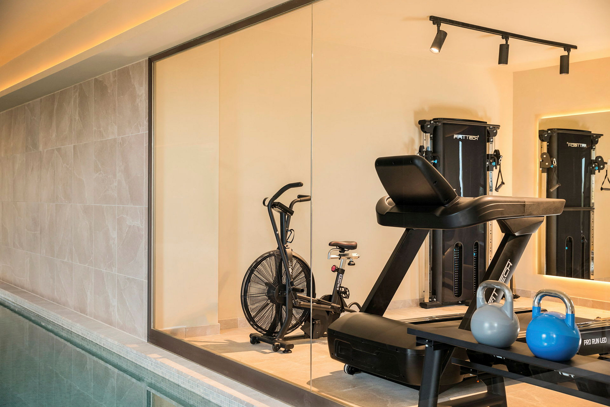 Et treningsstudio med treningsmaskiner, kettlebells og en treningssykkel i forgrunnen. (AI-generert tekst)