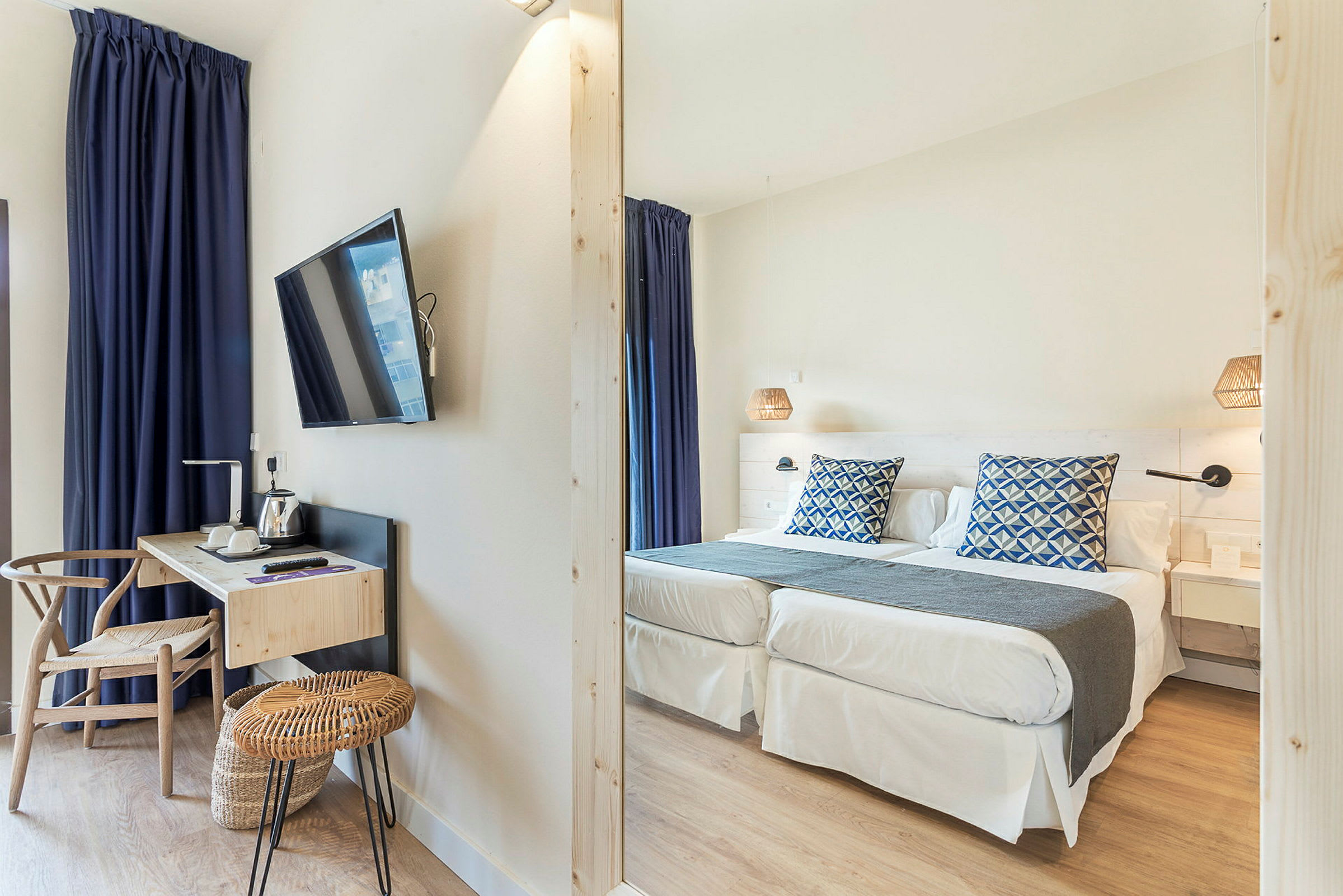 Hotellrom med to enkeltsenger, skrivebord og TV. (AI-generert tekst)