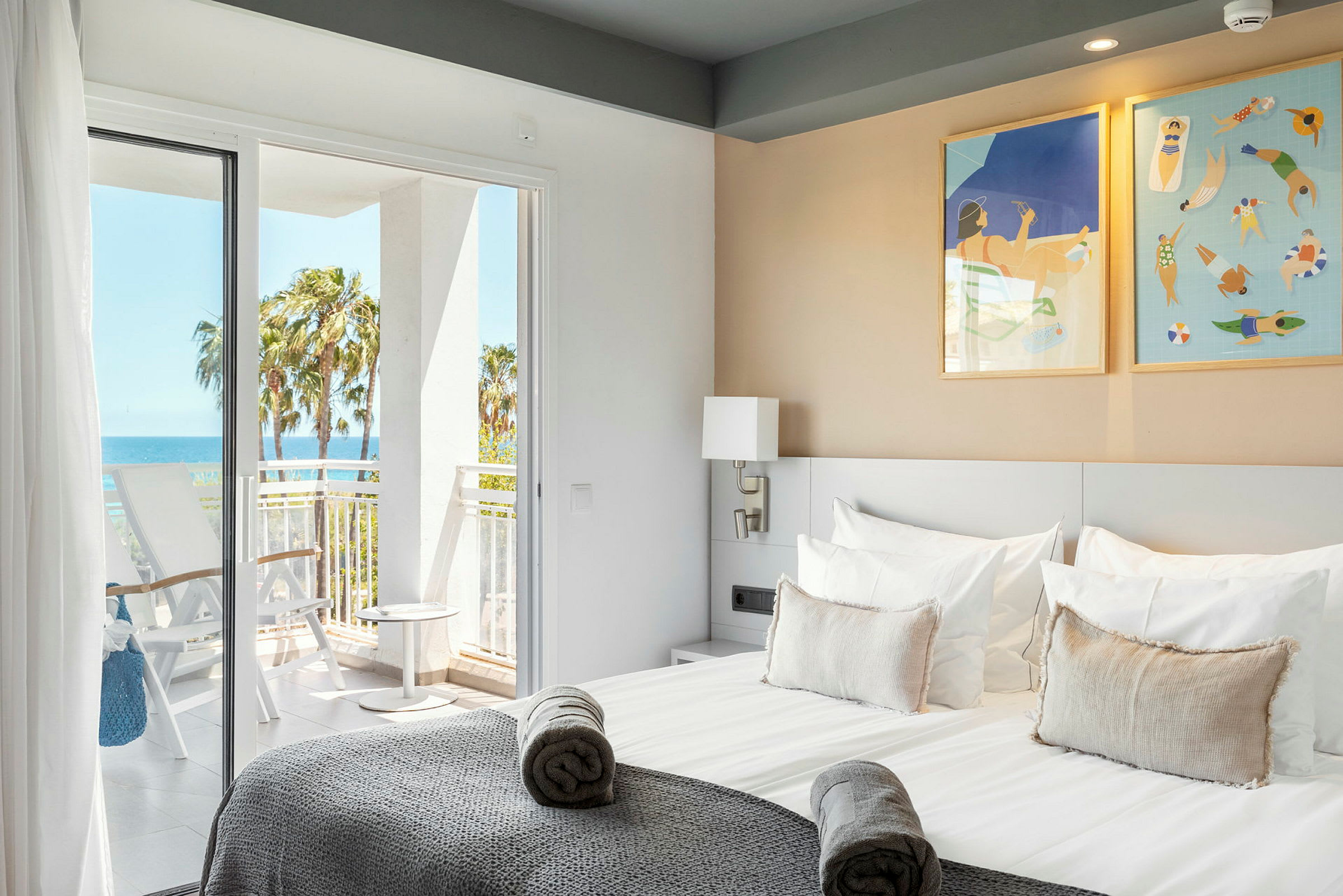 Hotellrom med en dobbeltseng, balkongdører og utsikt mot havet. (AI-generert tekst)