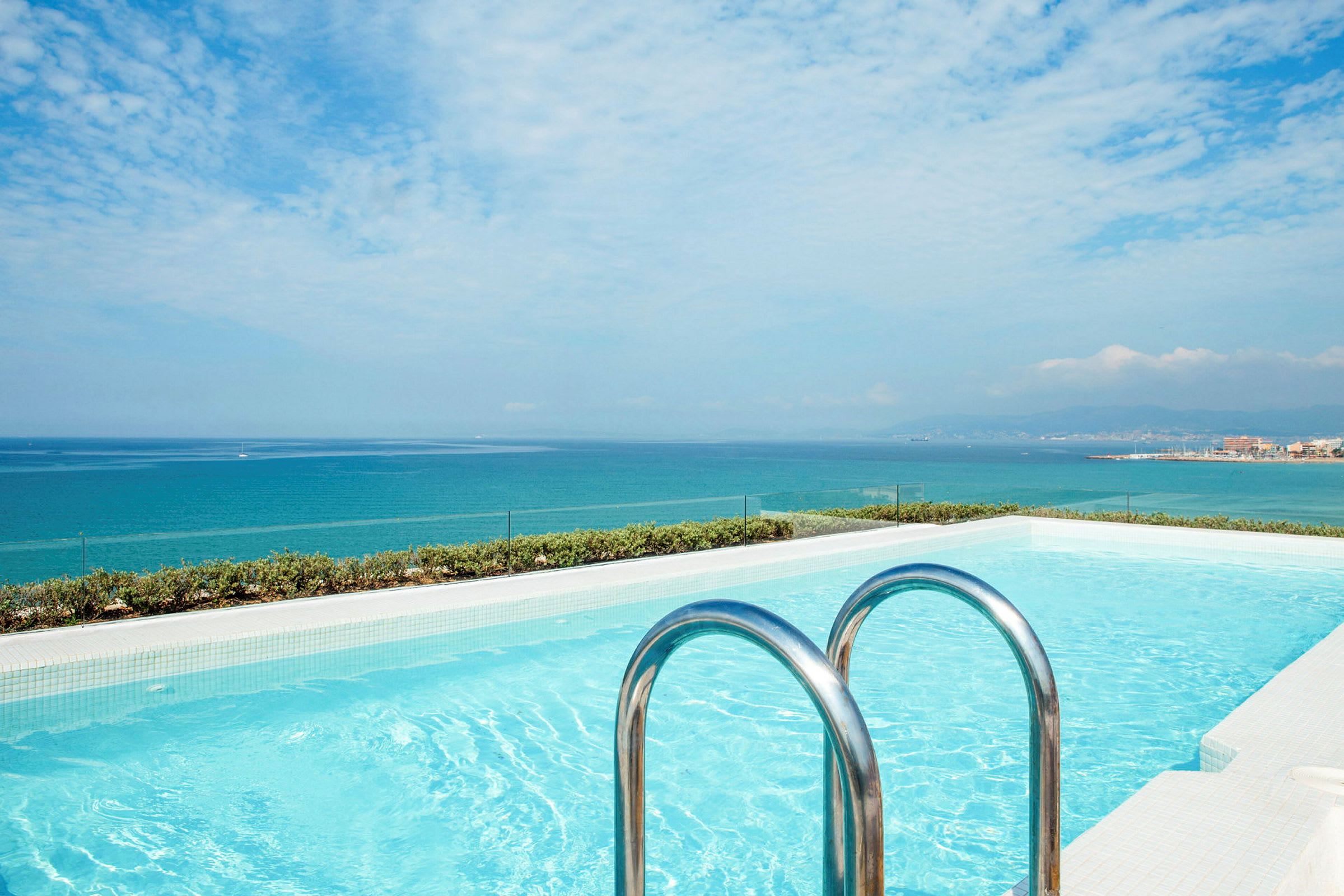 Et utendørs basseng med utsikt over havet. (AI-generert tekst)