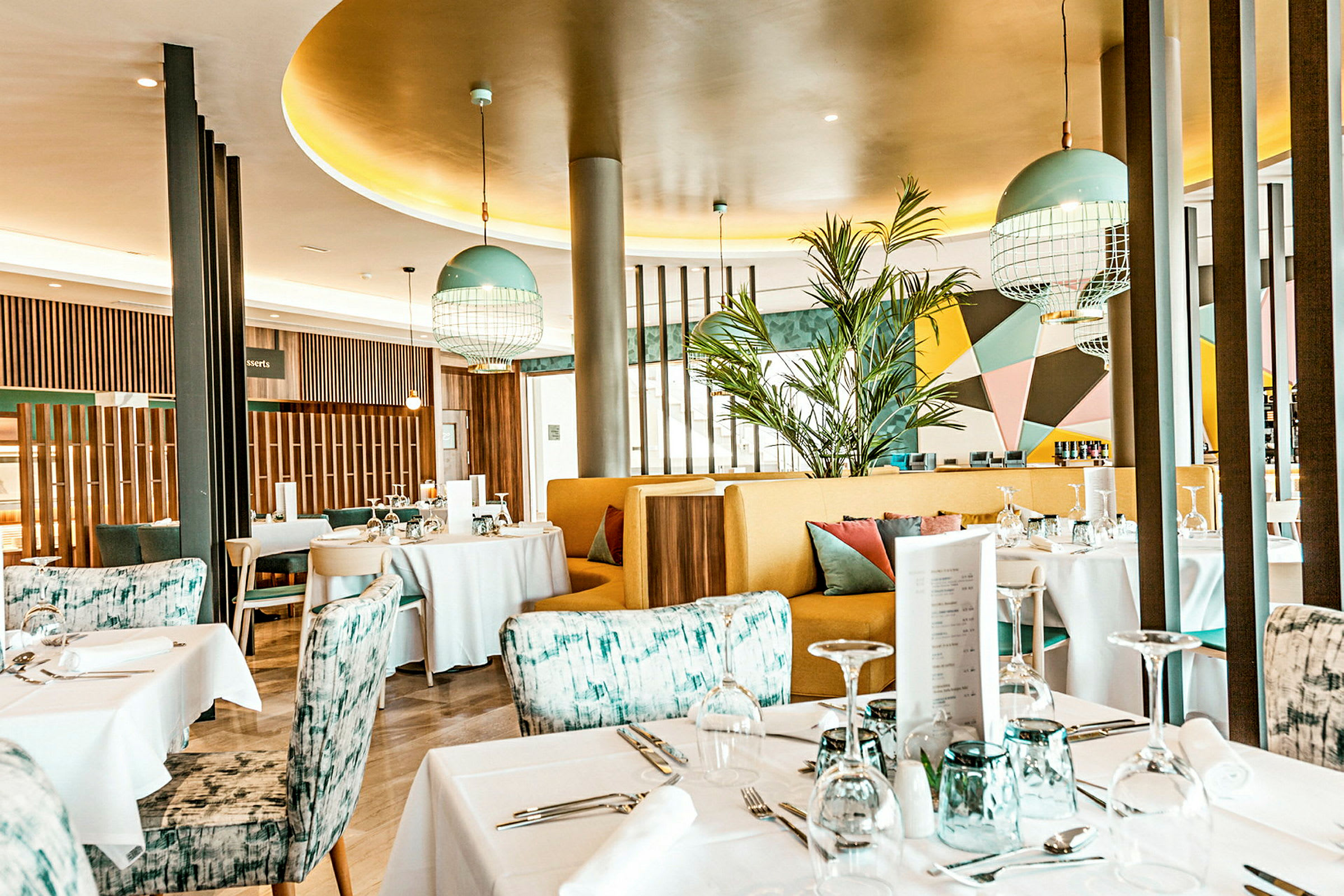 En moderne og fargerik restaurant med dekkede bord og stilfull innredning. (AI-generert tekst)