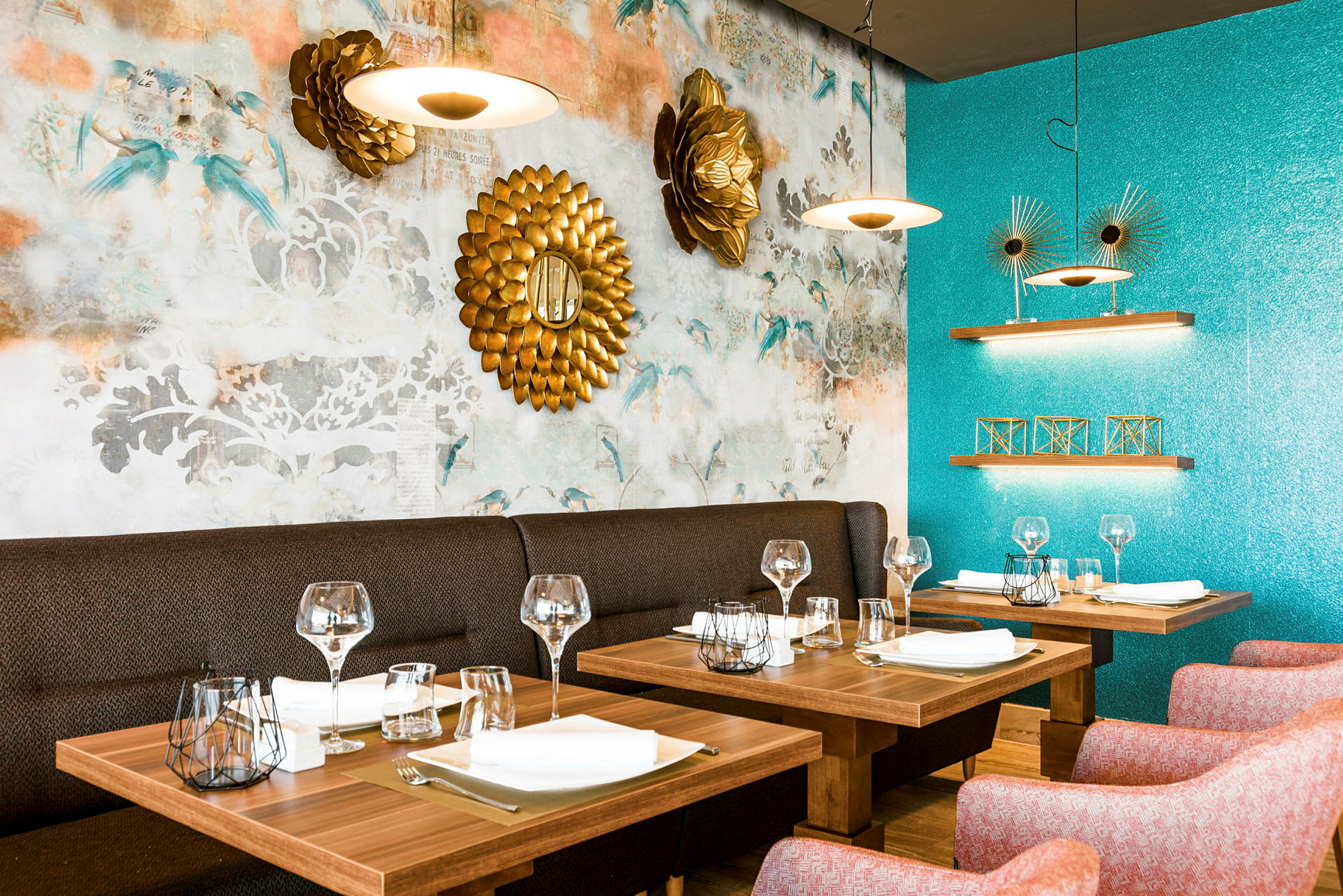 Interiør av en restaurant med dekkede trebord og dekorative gjenstander på turkise og mønstrede vegger. (AI-generert tekst)