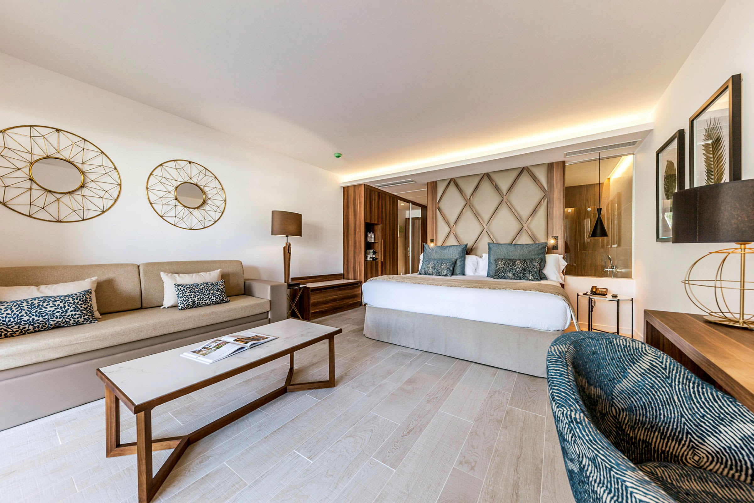 Et elegant hotellrom med en dobbeltseng, en sofa, et sofabord og moderne interiørdetaljer. (AI-generert tekst)
