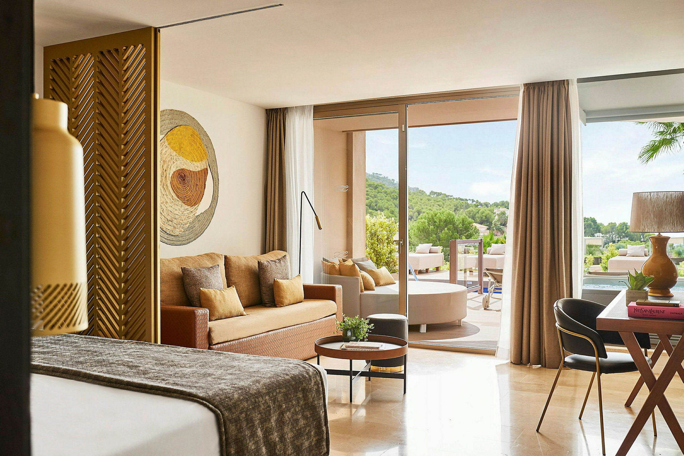Et moderne hotellrom med sittegruppe og en uteplass med utsikt over natur. (AI-generert tekst)