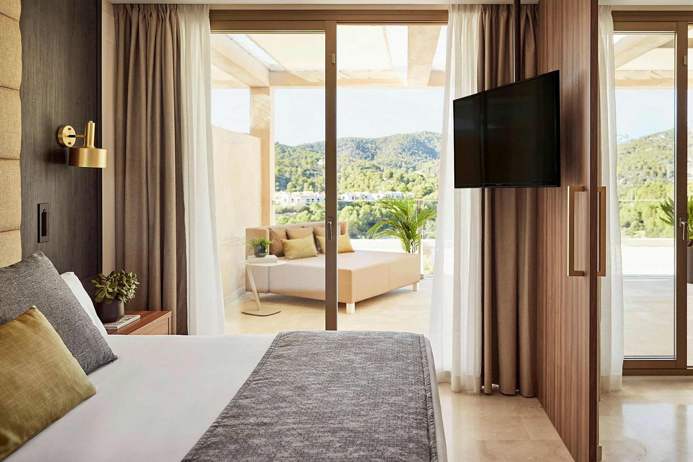 Et hotellrom med seng, uteområde med sitteplass og en TV. (AI-generert tekst)