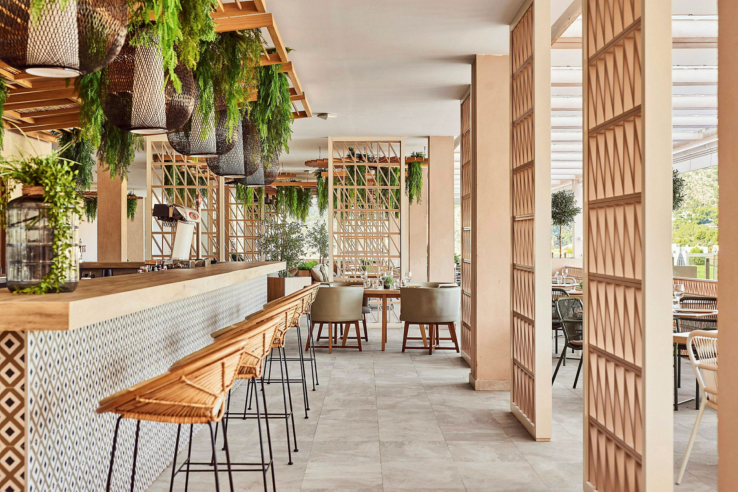 Et moderne restaurantmiljø med barkrakker, bord og grønne planter. (AI-generert tekst)