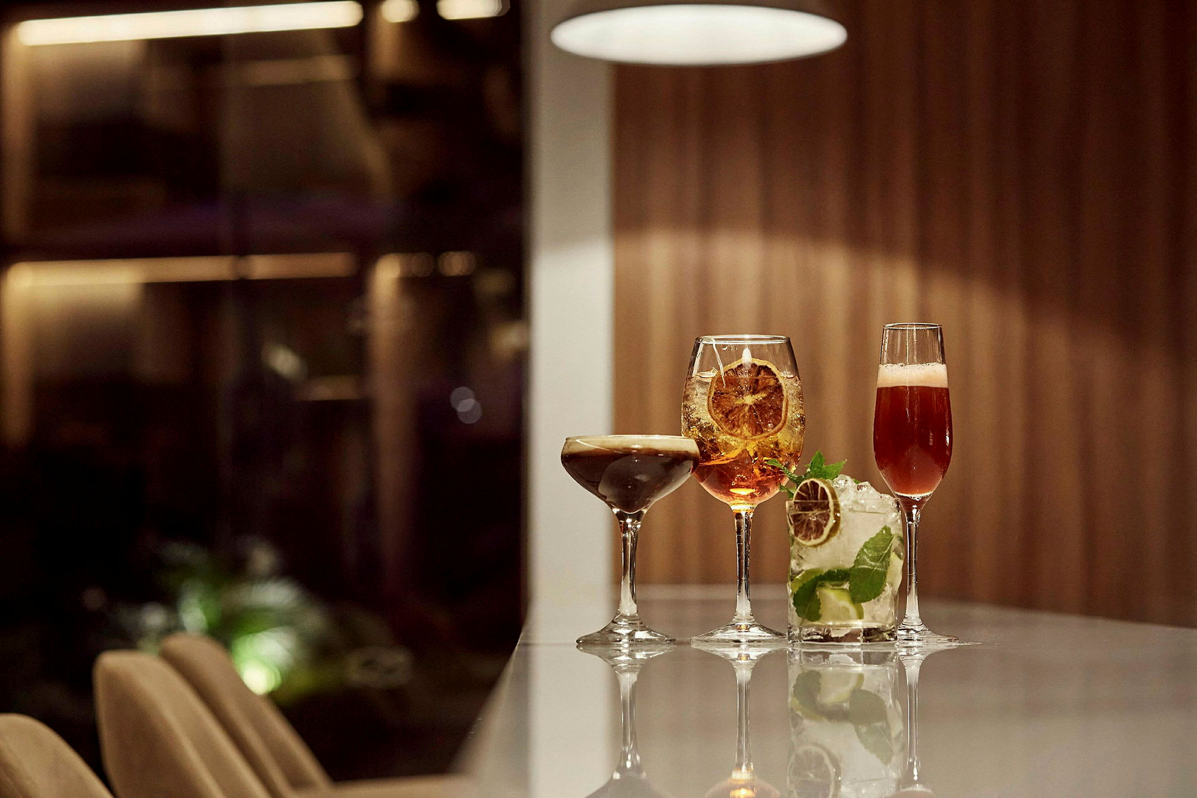 Fire cocktails på et bord i et elegant miljø. (AI-generert tekst)