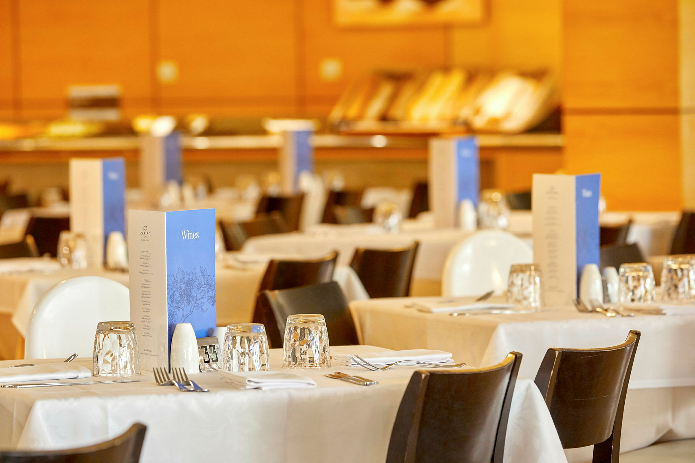 Bilde av dekkede bord i en restaurant med menyer plassert på hvert bord. (AI-generert tekst)